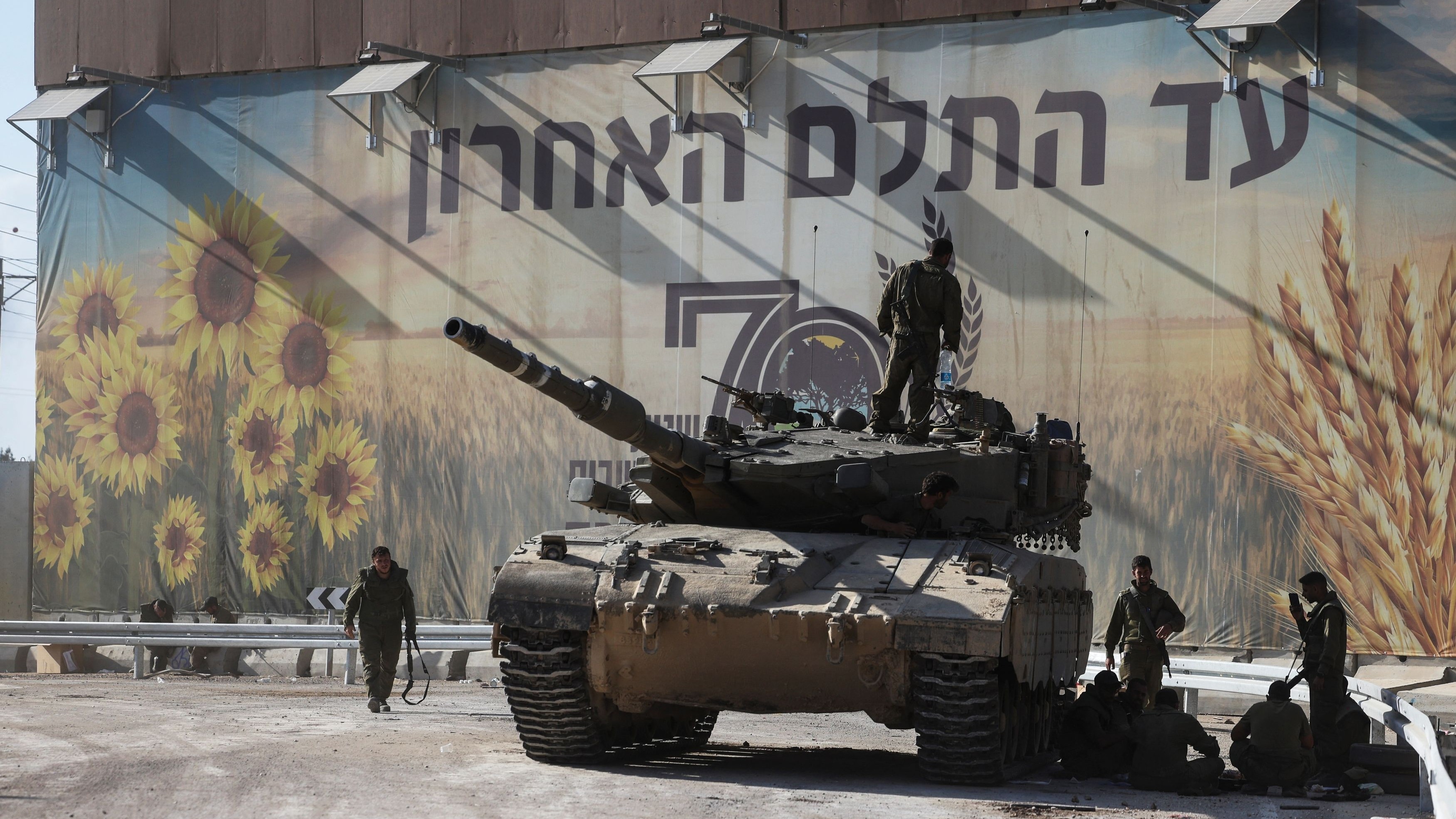 Israeli soldiers gather on and around a tank near the country's border with the Gaza Strip, in southern Israel, October 15, 2023.