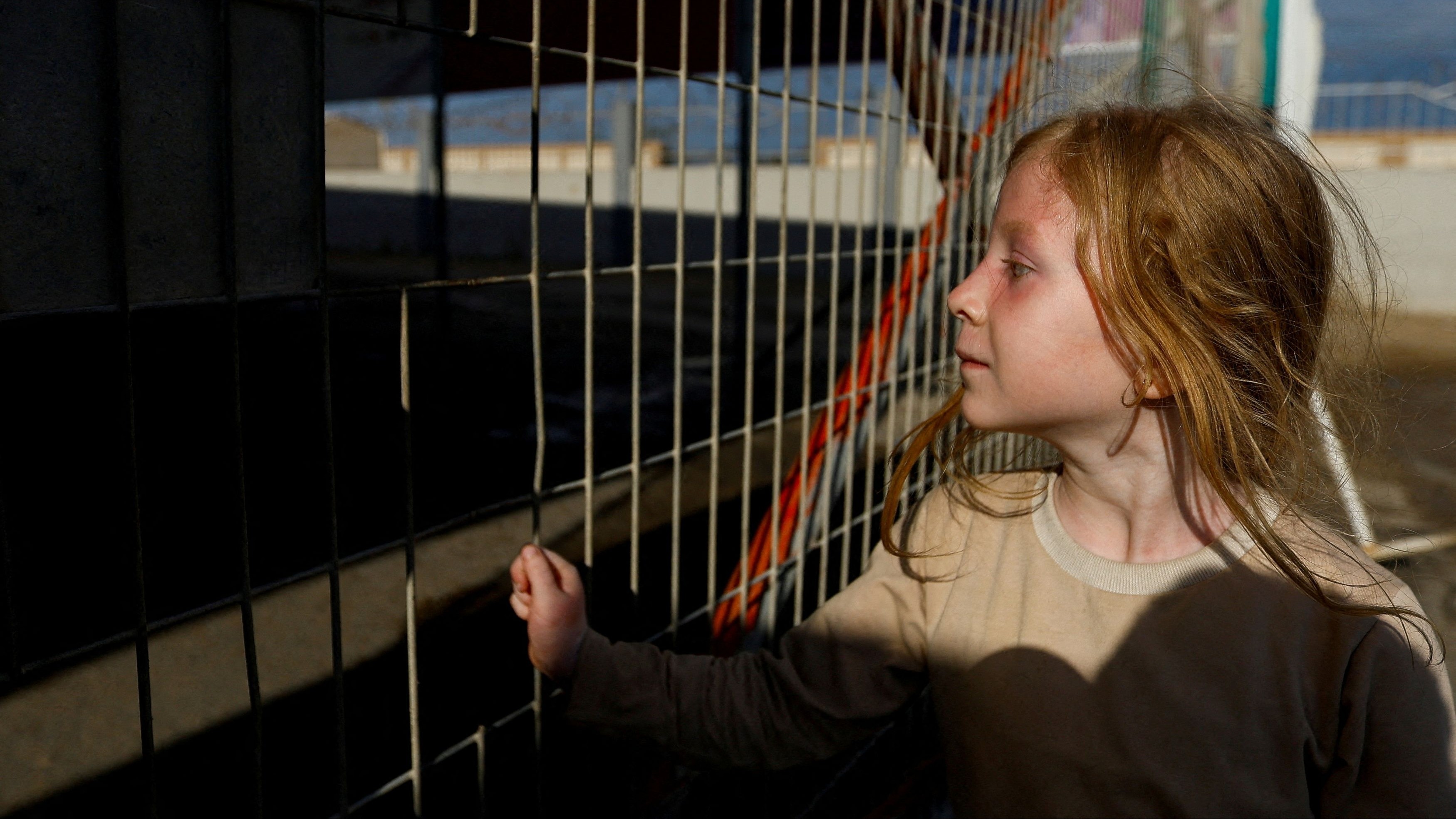 A Palestinian girl with dual citizenship waits outside the Rafah border crossing with Egypt in the hope of getting permission to leave Gaza, amid the ongoing Israeli-Palestinian conflict, in Rafah in the southern Gaza Strip on October 17, 2023. 