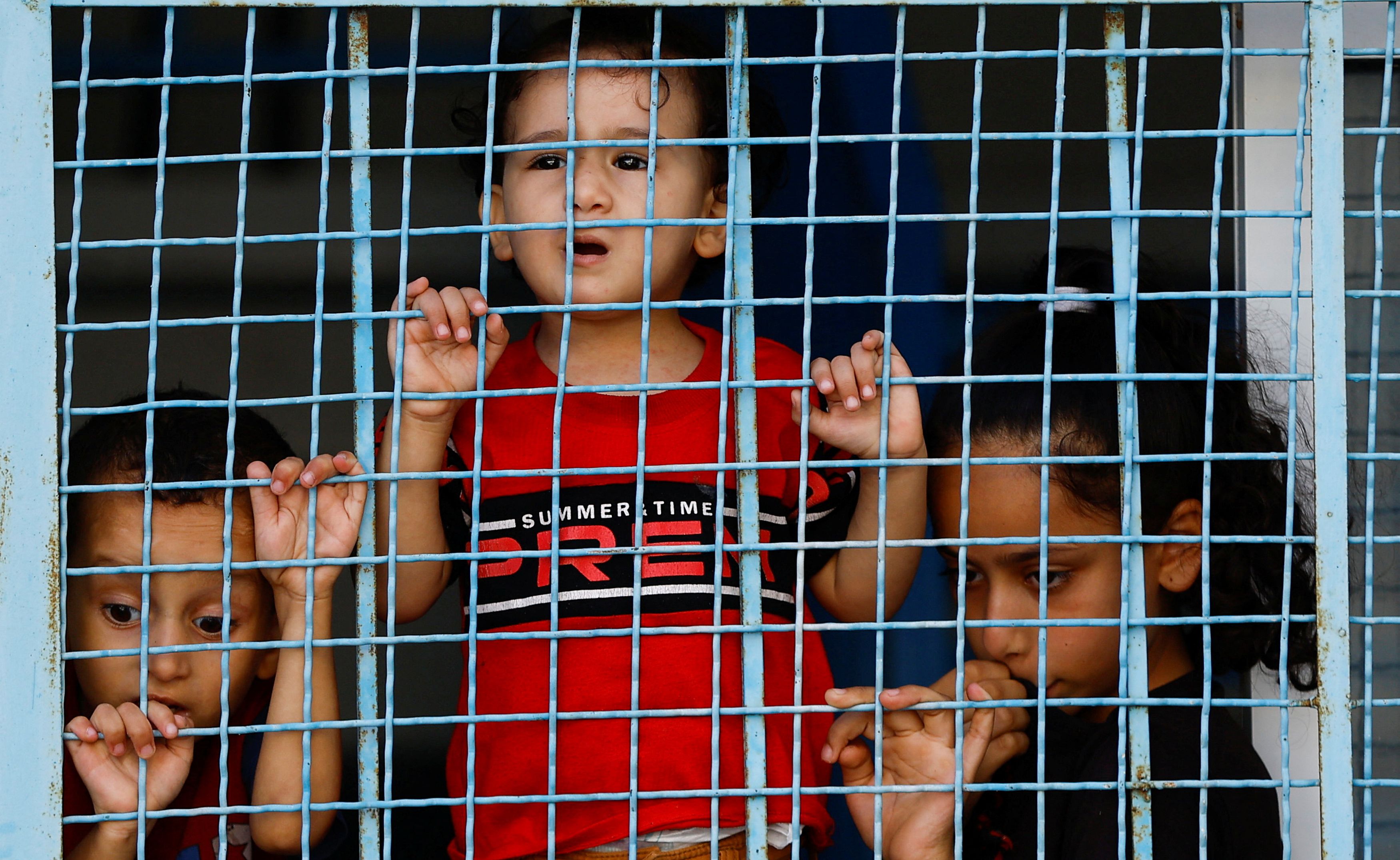 Palestinian children, who fled their house amid Israeli strikes, shelter at a United Nations-run centre after Israel's call for more than 1 million civilians in northern Gaza to move south, in Khan Younis in the southern Gaza Strip, October 18, 2023.