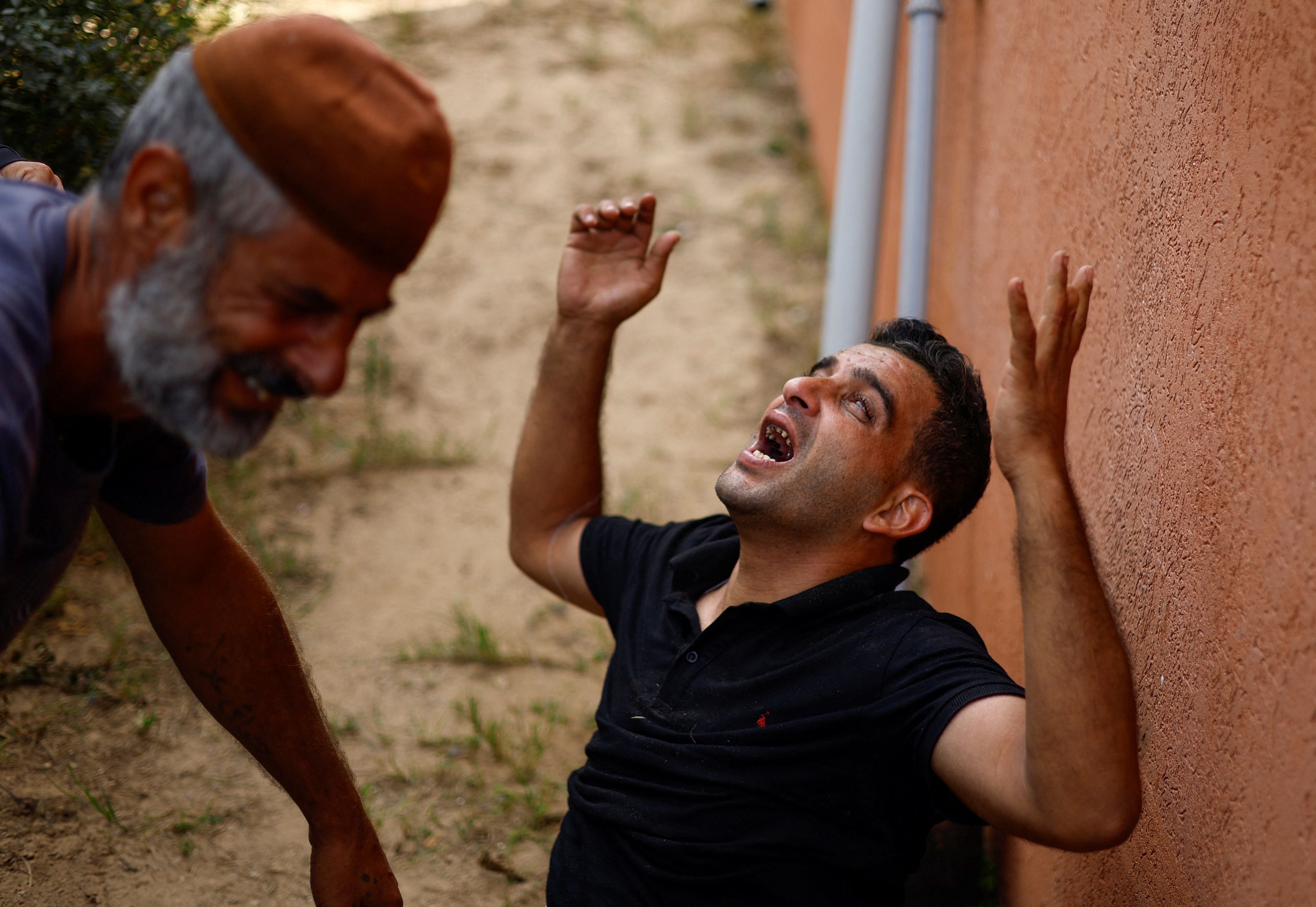 Mourners react next to the bodies of Palestinians killed in Israeli strikes, at a hospital in Khan Younis in the southern Gaza Strip, October 17, 2023. 