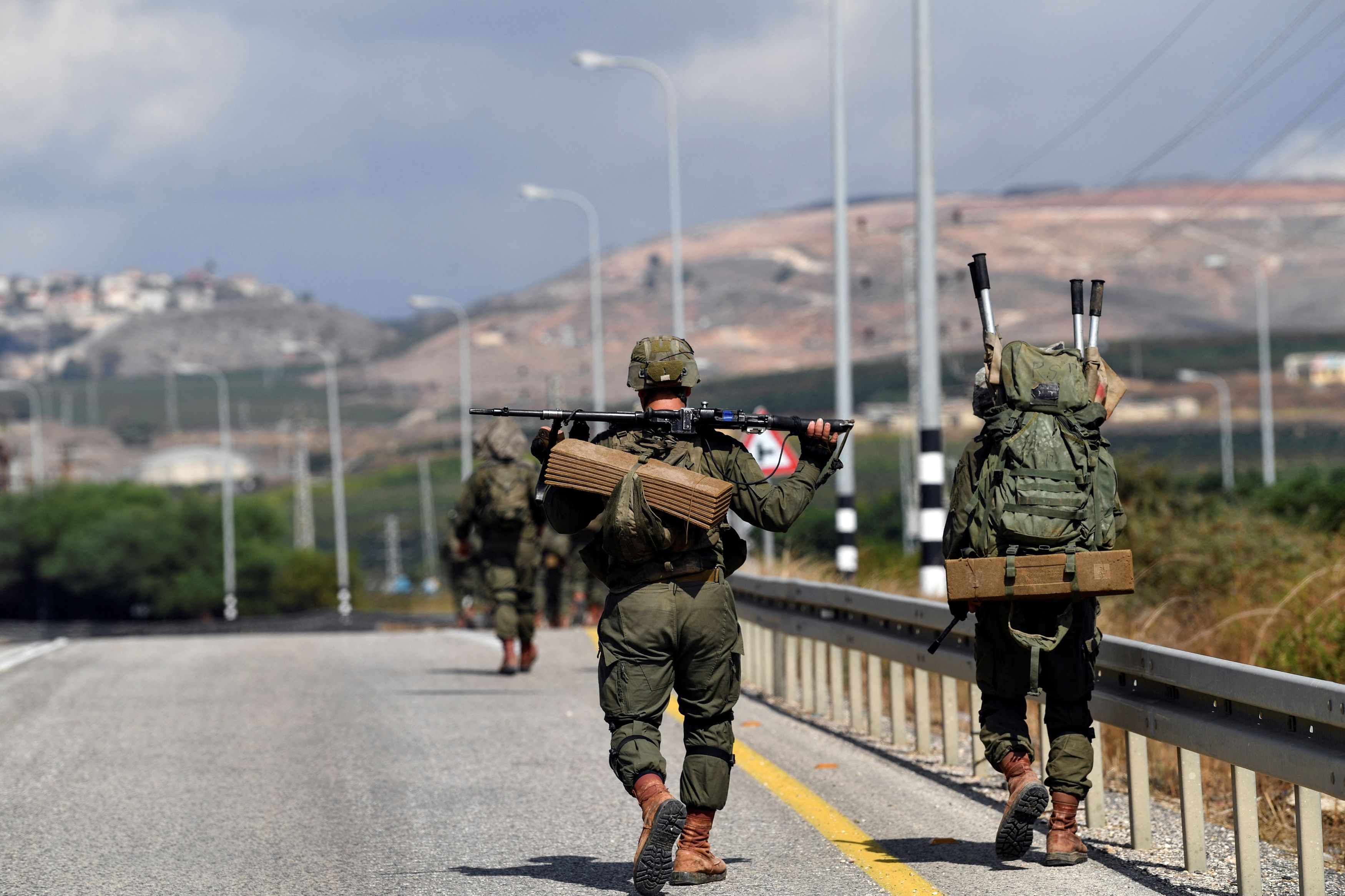 Israeli soldiers walk on a road near the Israel border with Lebanon amid heightened tensions between Israel and Lebanon, in northern Israel, October 19, 2023.