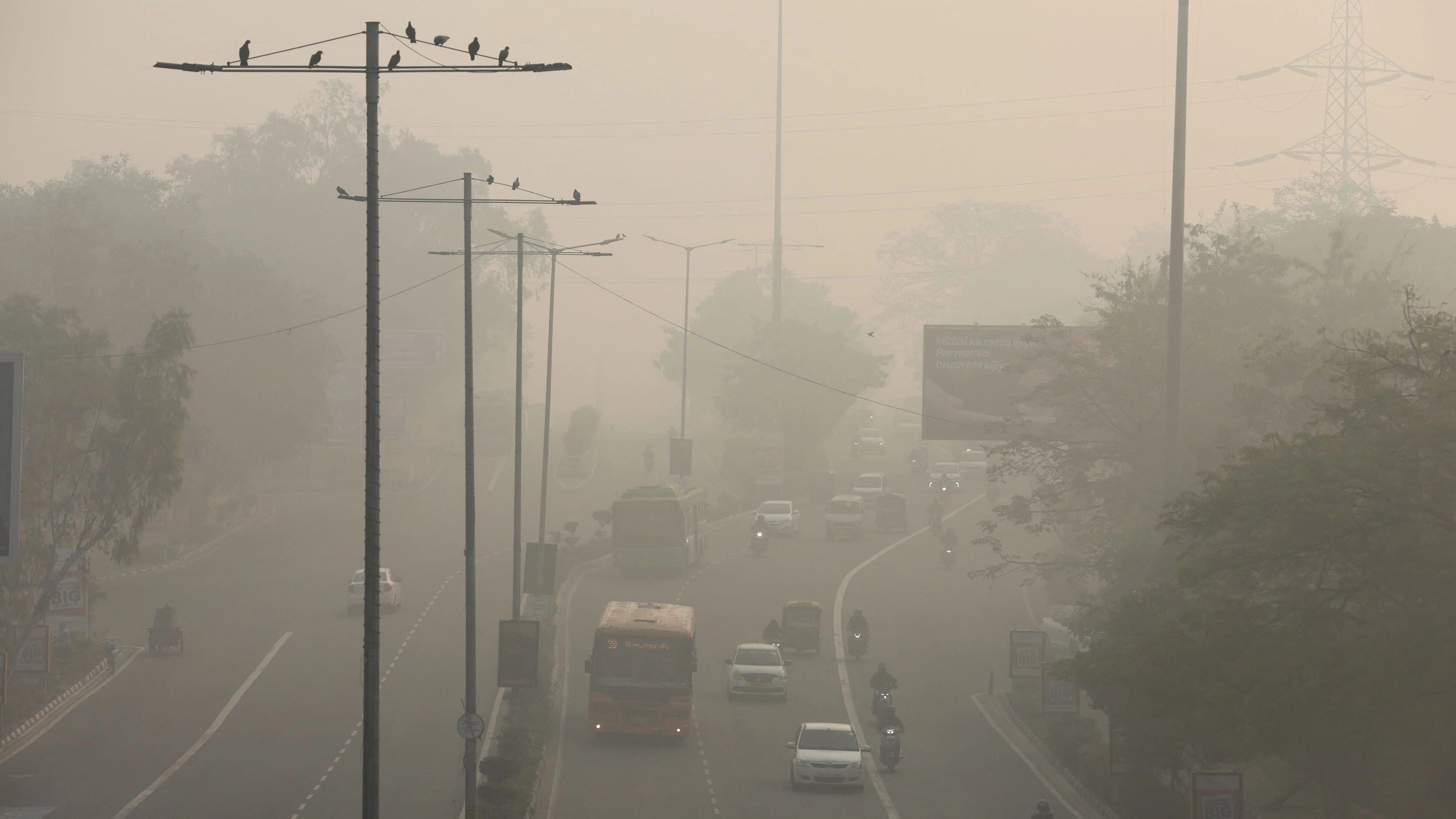 Traffic plies on a road, on a smoggy morning, in New Delhi. 