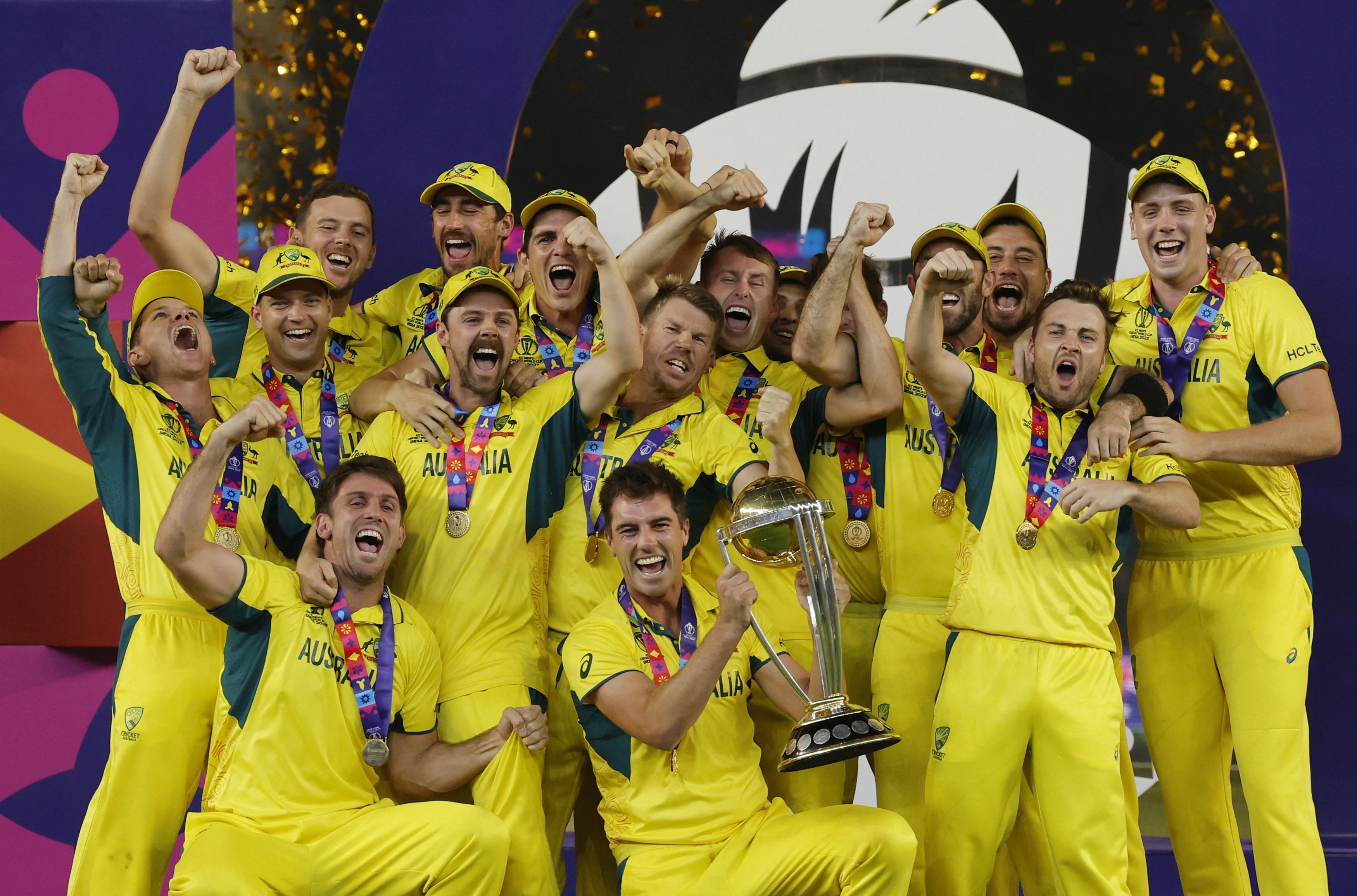   Australia's Pat Cummins celebrates with the trophy and teammates after winning the ICC Cricket World Cup.