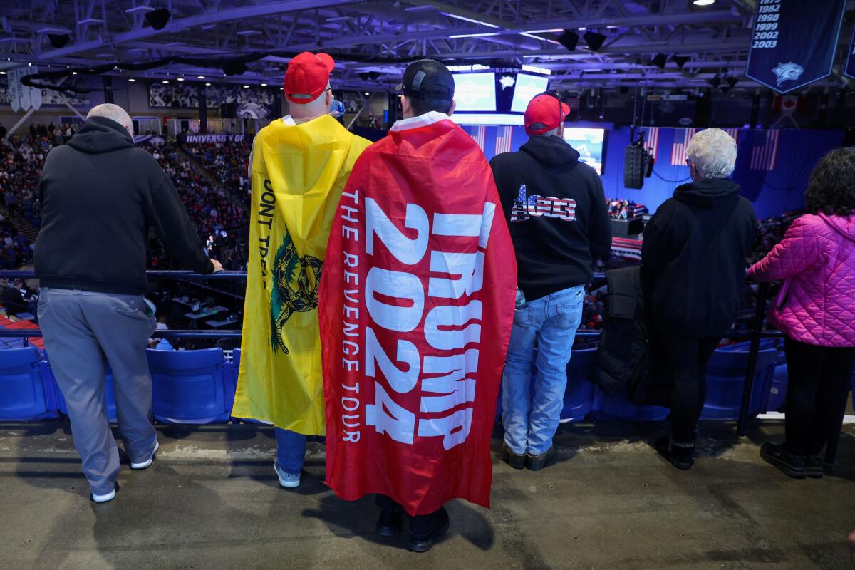 Supporters of Republican presidential candidate and former U.S. President Donald Trump wear flags on the day of his rally in Durham, New Hampshire.