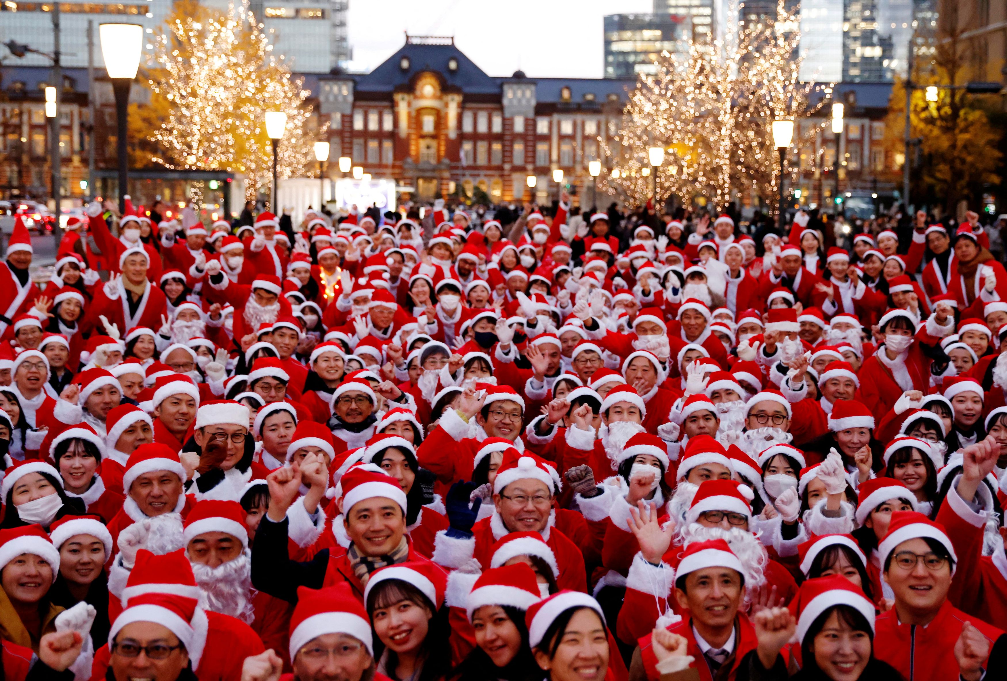 Participants wearing Santa Claus outfits pose for photos before their event to hand out gifts and clean up the street to celebrate the upcoming Christmas season in Tokyo, Japan December 22, 2023.