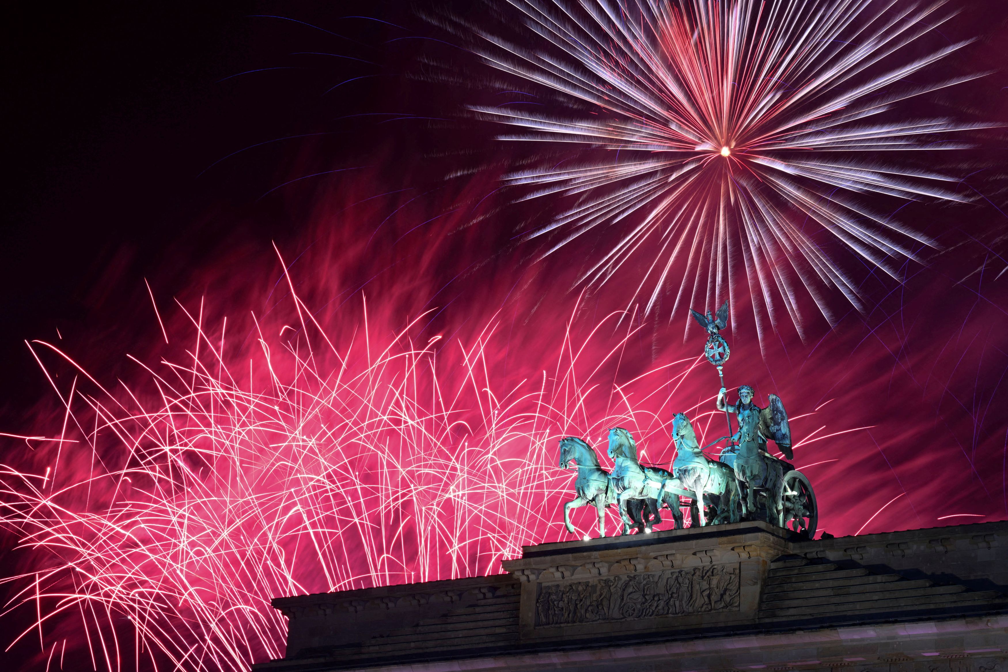 Fireworks illuminate Quadriga sculpture atop the Brandenburg Gate, during New Year's Eve celebrations in Berlin, Germany January 1, 2024. REUTERS/Annegret Hilse    