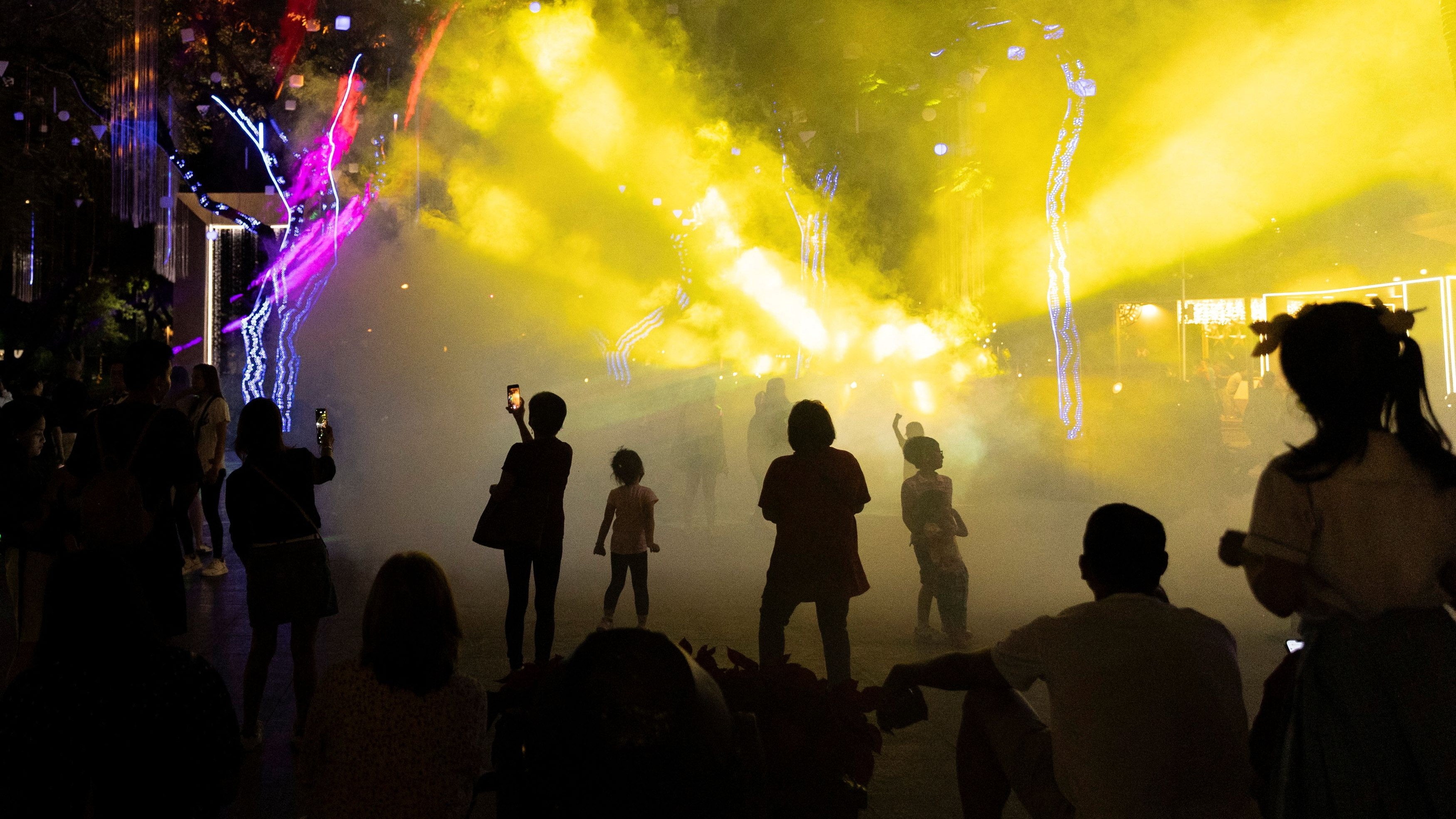People watch a Christmas light show at the Ayala Triangle Gardens, operated by Ayala Land Inc., in Makati, Metro Manila, Philippines. 