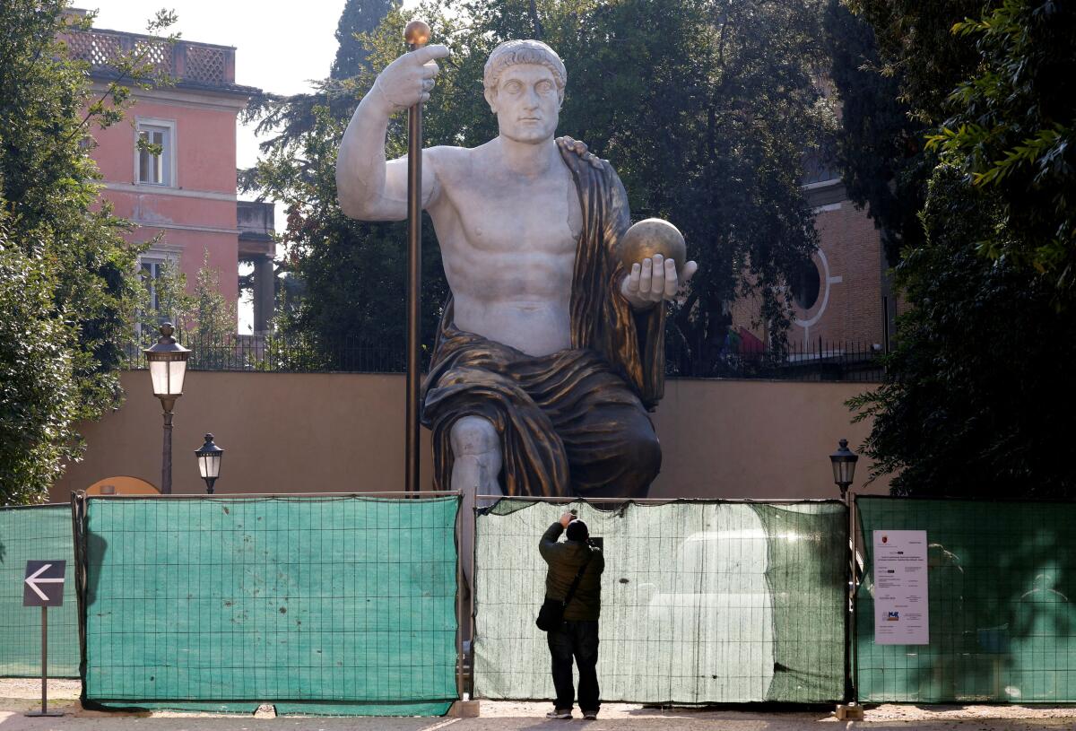A man takes a picture of a reconstruction of the giant statue Colossus of Constantine in Rome, Italy, February 1, 2024. The statue, reconstructed in full 12-meter height with 3D printing technology, will go on public display on February 6, 2024.