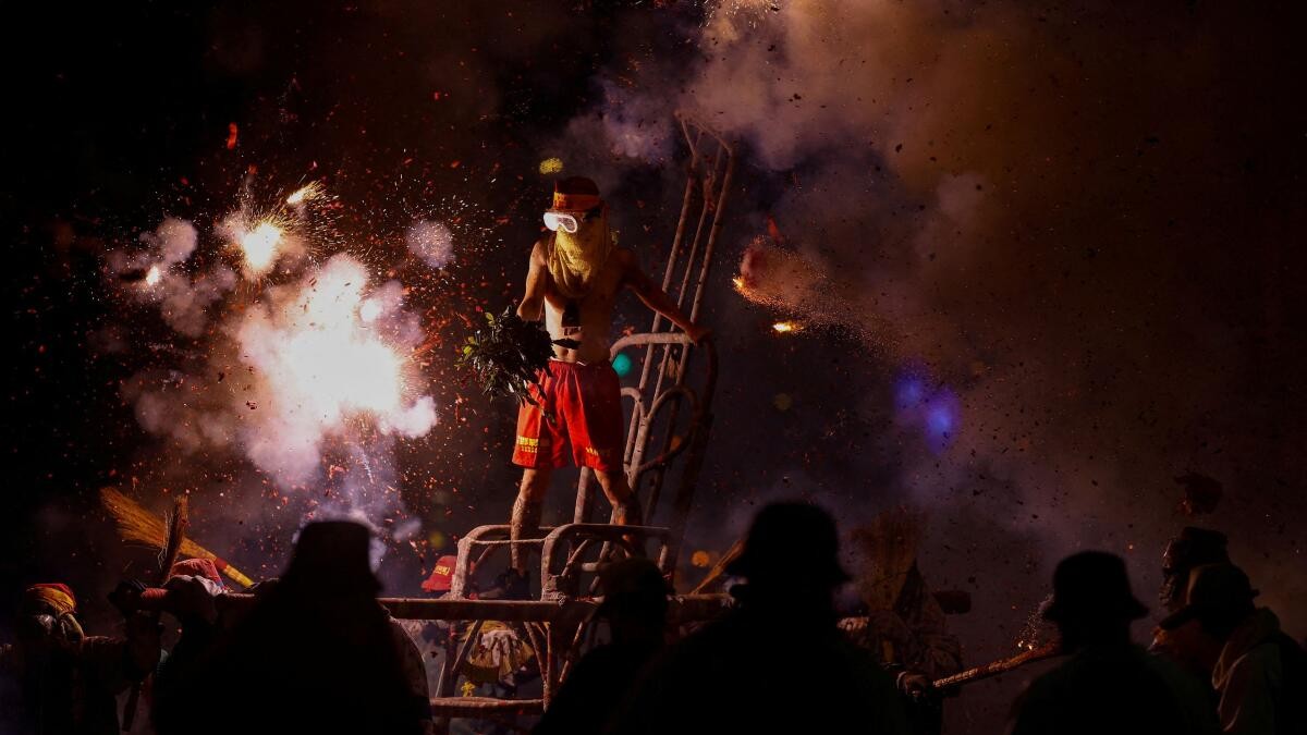 A volunteer is pelted with exploding firecrackers as part of the Lantern Festival celebrations in Taitung.