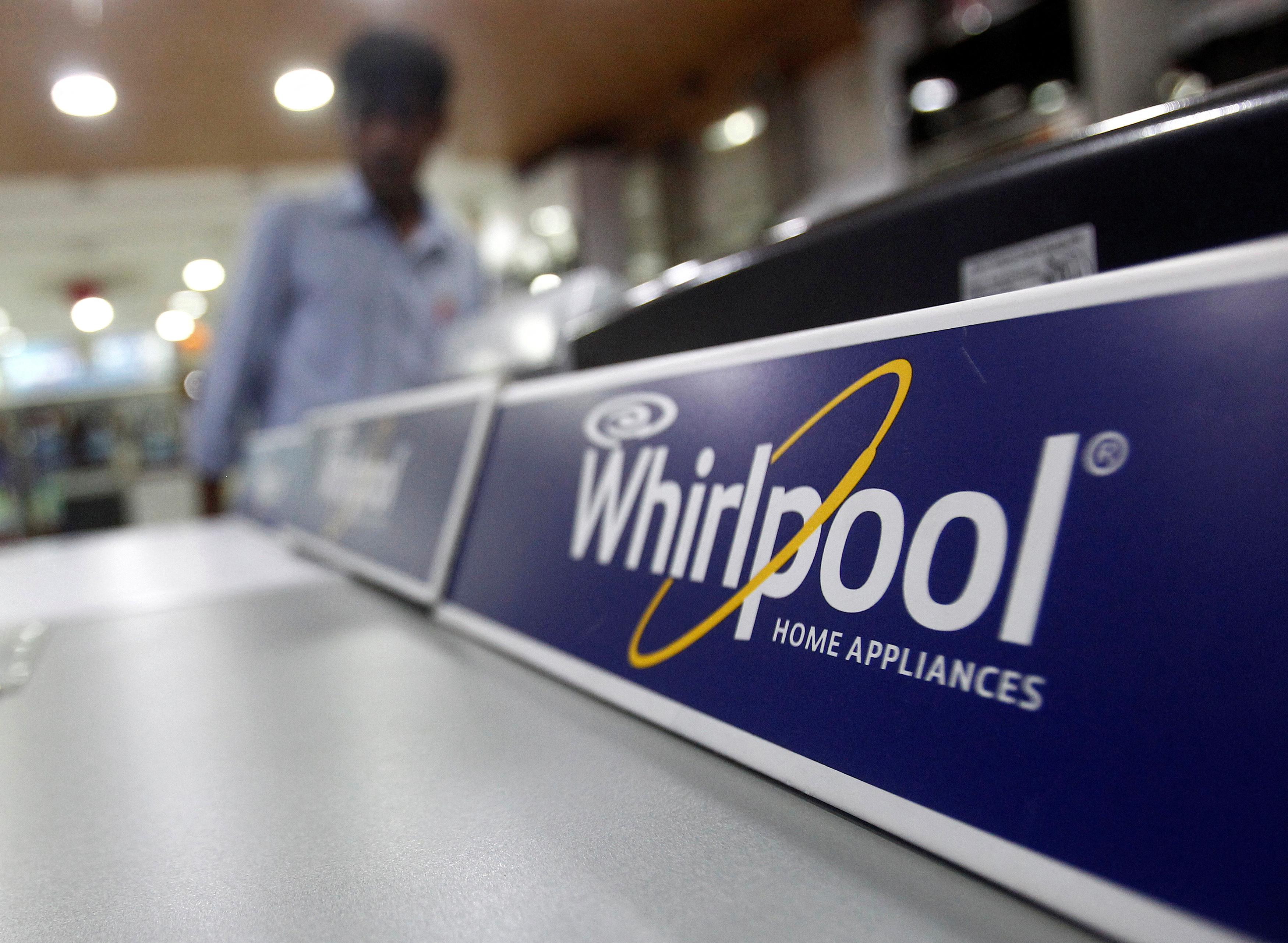 FILE PHOTO: An employee stands next to a Whirlpool washing machine inside a home appliances showroom in New Delhi August 27, 2013. REUTERS/Anindito Mukherjee/File Photo