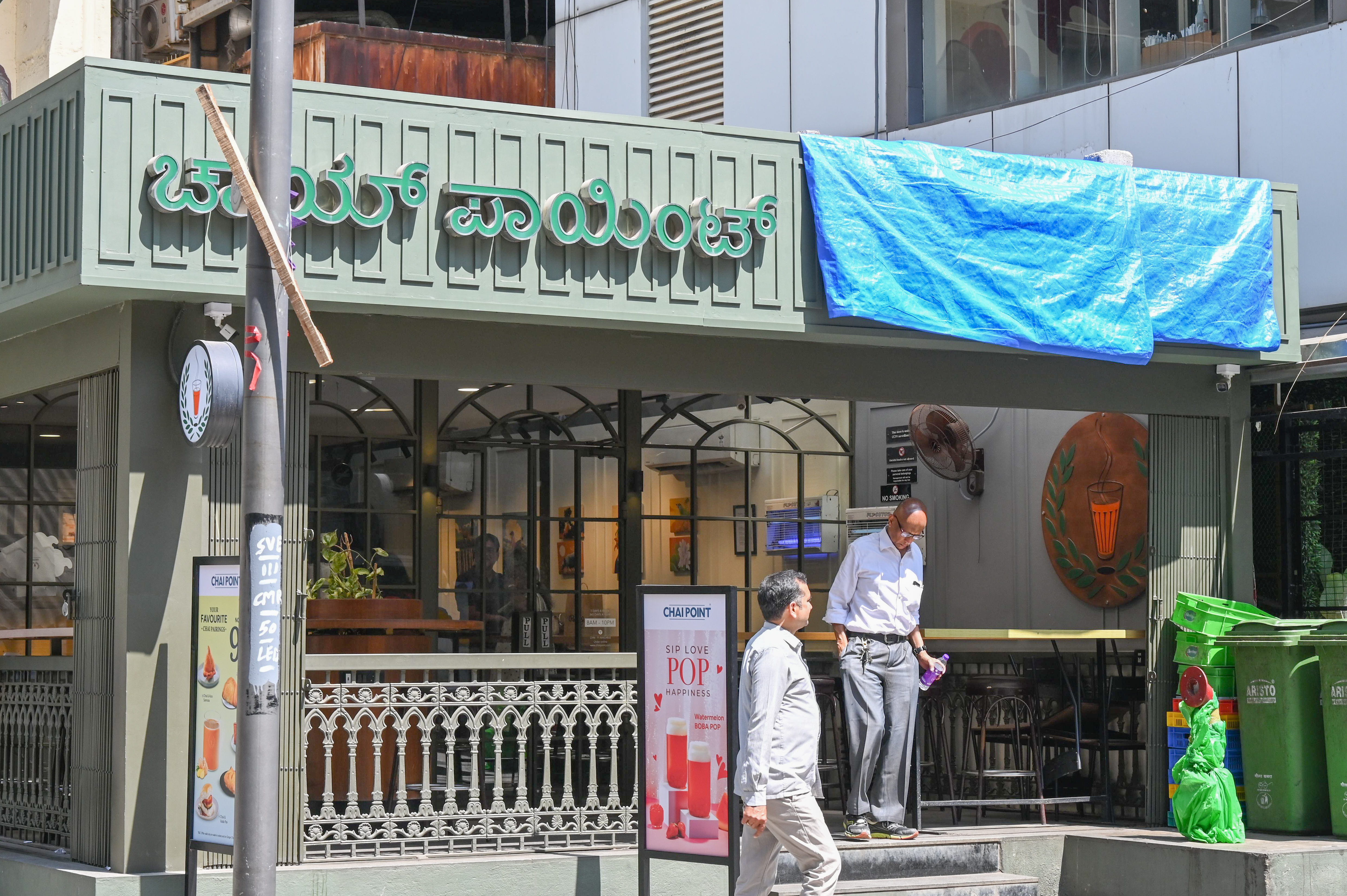 BBMP officials instruct shop owners at Church Street to cover the signboards. 