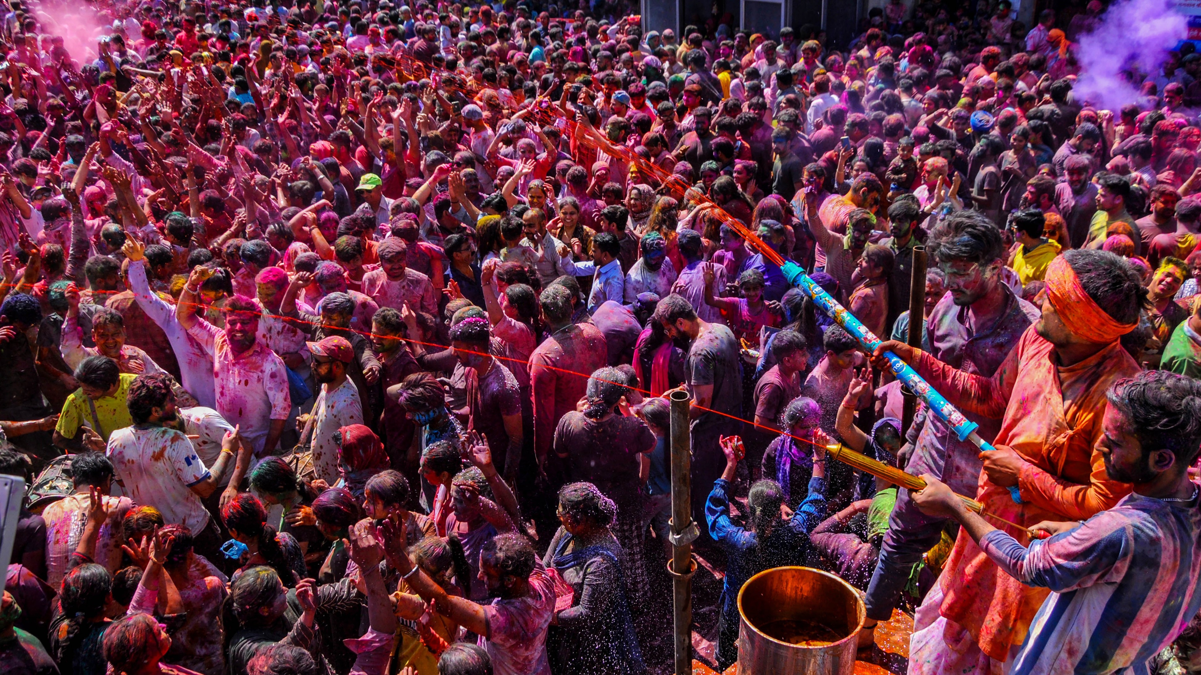 People play with colour and spray water on each other during Holi festival celebrations, at Durgiana Temple in Amritsar.