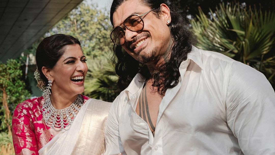 Varalaxmi looked resplendent in an ivory and gold silk saree with a diamond neck piece. Nicholai complemented her look with a matching shades of shirt and dhoti.