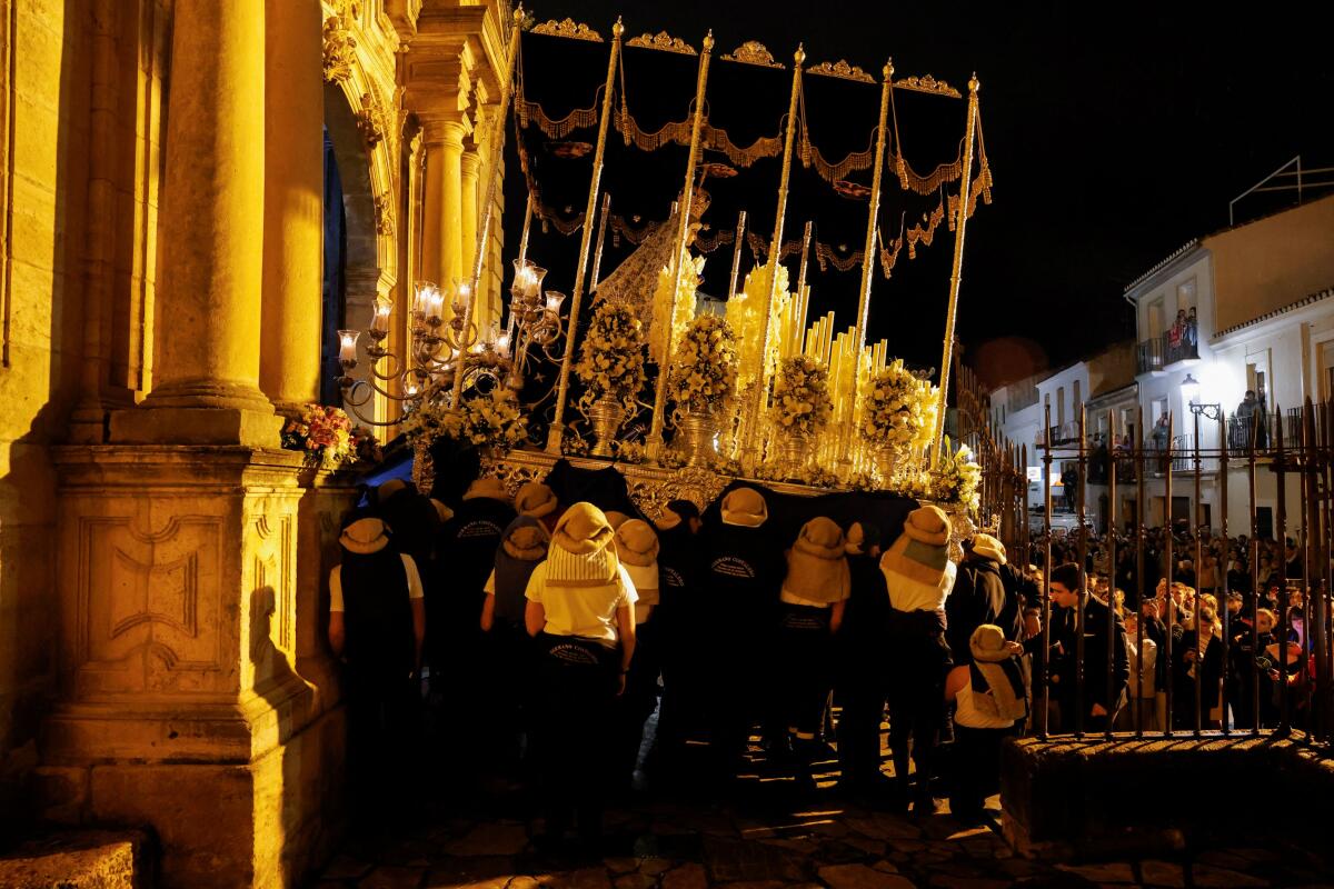 'Costaleros' belonging to Huerto brotherhood carry a statue of the Virgin Mary on a structure traditionally known as 'paso', as they leave a church to take part in a procession during the Holy Week in Ronda, Spain.
