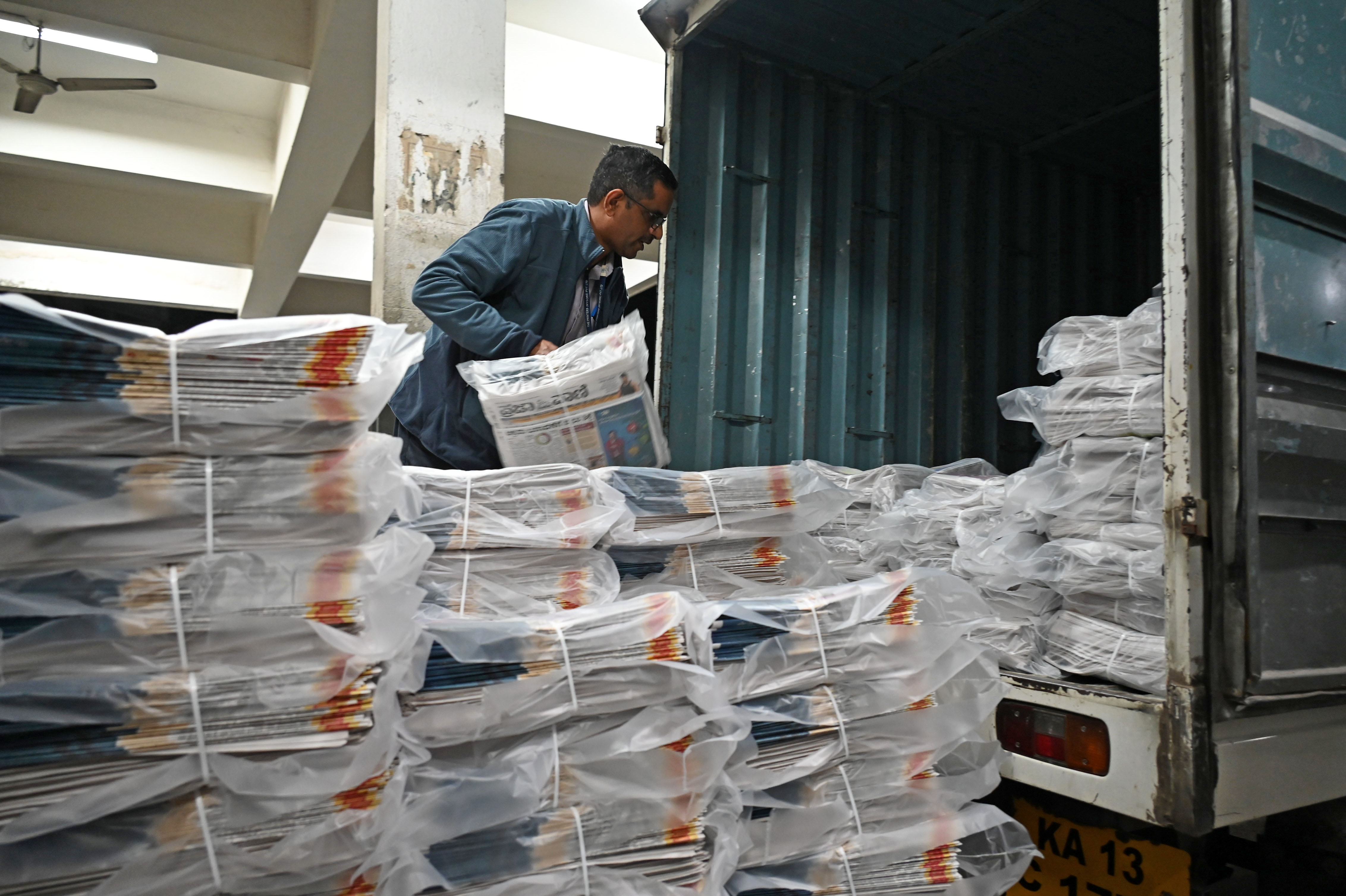 Editor loads freshly printed copies in a dispatch van