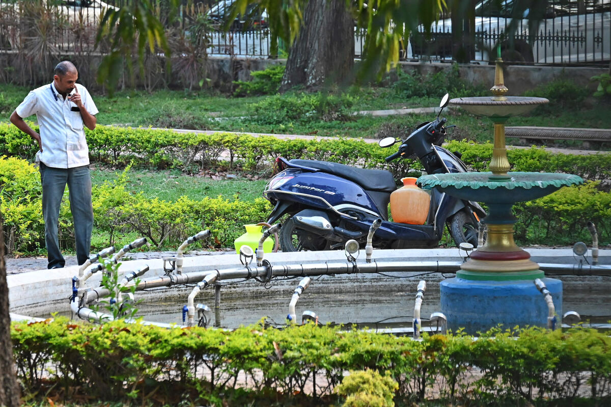 Amid severe water crisis, a man fills water in plastic pots from Cubbon Park fountain on his scooter on Thursday.