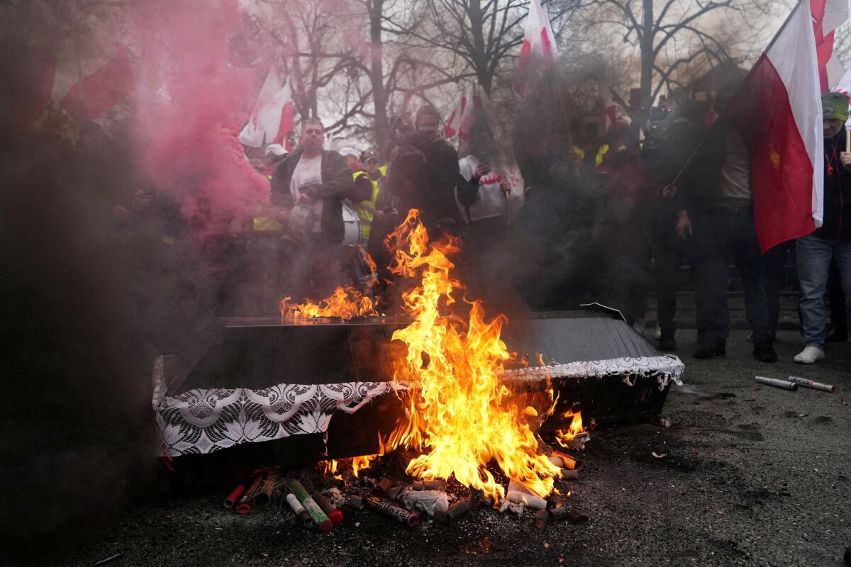 Farmers burn a mock casket as they protest outside Polish Prime Minister Donald Tusk's office against the European Union's Green Deal and imports of Ukrainian agricultural products, in Warsaw, Poland