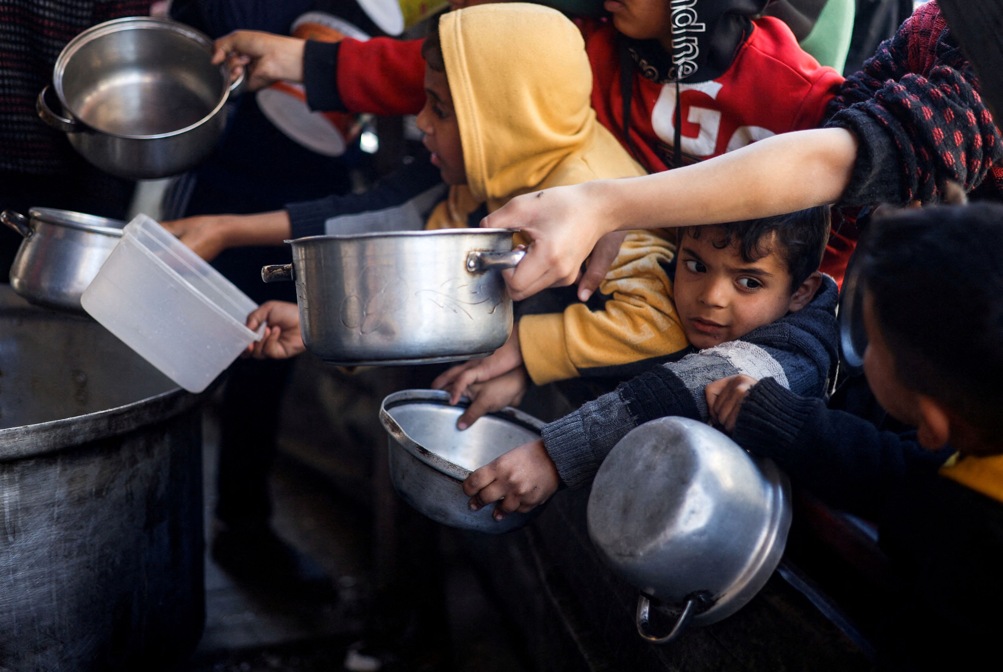 Palestinian children wait to receive food cooked by a charity kitchen amid shortages of food supplies, as the conflict between Israel and the Palestinian Islamist group Hamas continues, in Rafah, in the southern Gaza Strip, March 5, 2024.