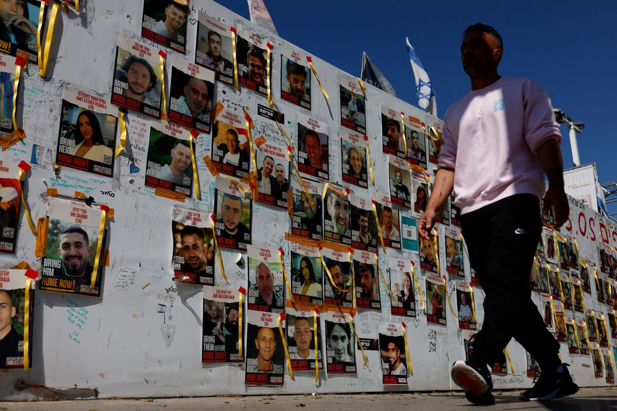 A man walks past placards with photos of hostages kidnapped in the deadly October 7 attack on Israel by the Palestinian Islamist group Hamas from Gaza, in Tel Aviv, Israel March 11, 2024.