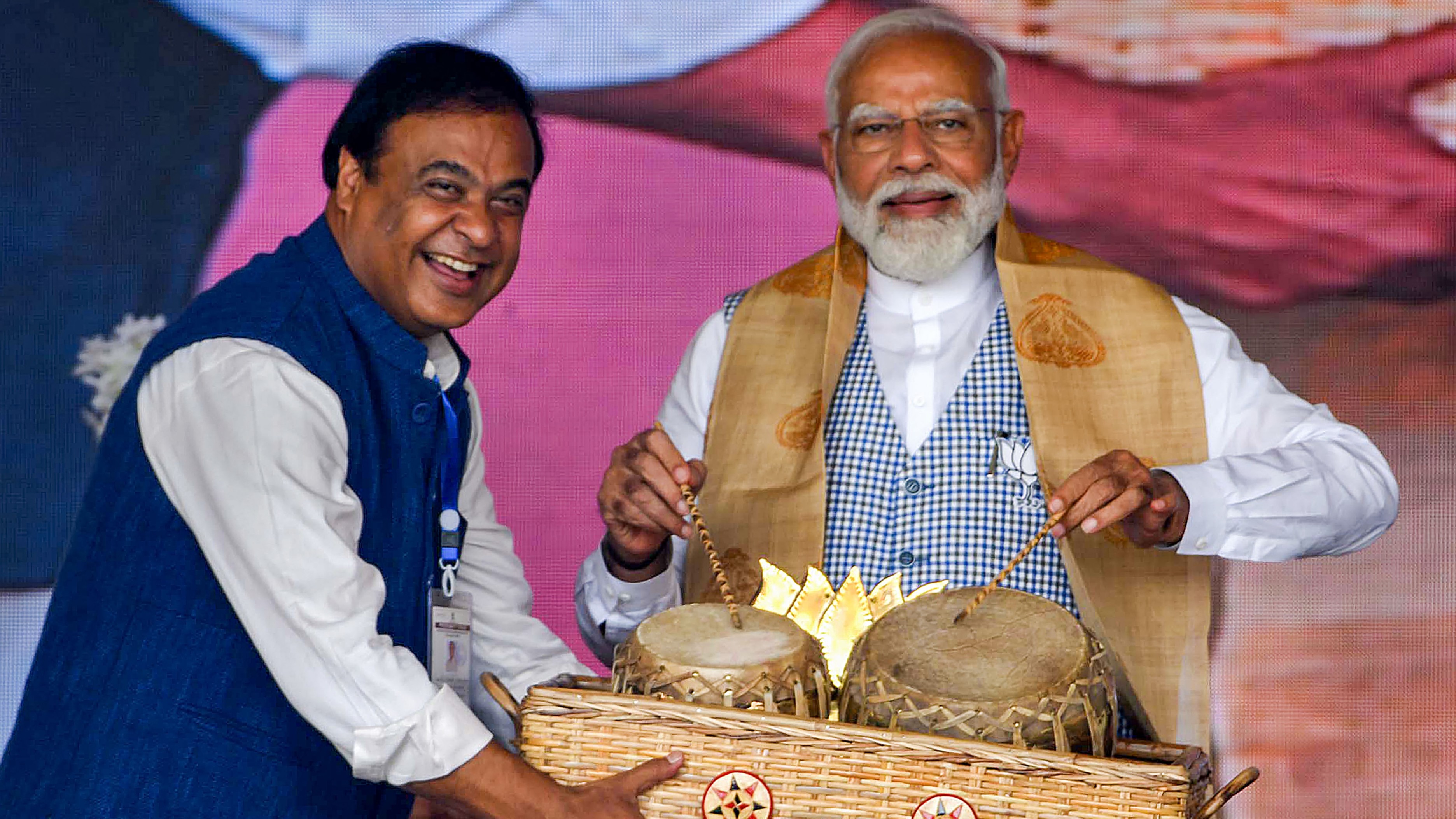Prime Minister Narendra Modi tries his hands on playing a traditional instrument during a public rally in Nalbari, Assam.