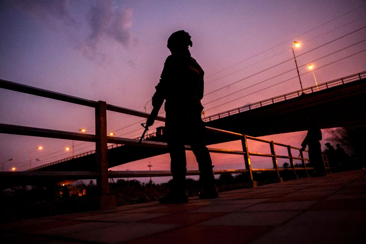 Military personnel stand guard as hundreds of refugees crossed over the river frontier between Myanmar and Thailand on Friday, following the fall of a strategic border town to rebels fighting Myanmar's military junta, in Mae Sot, Tak province, Thailand, April 13, 2024.
