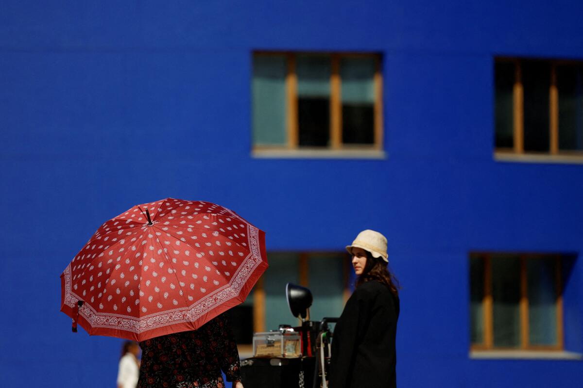 A woman protects herself from the sun during hot weather in Bilbao, Spain, April 13, 2024.