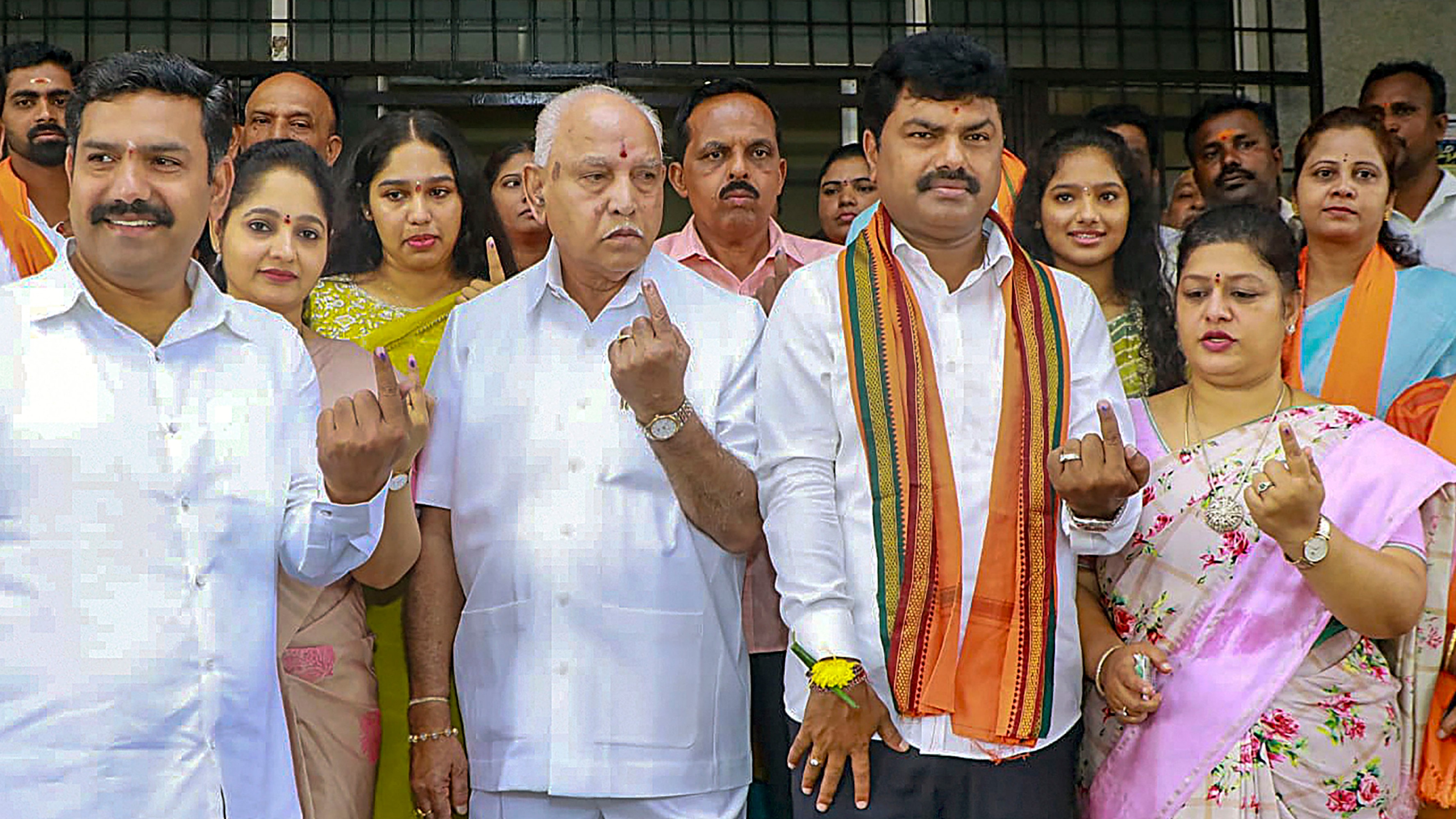 BJP leader BS Yediyurappa with MLA BY Vijayendra and other family members show their inked fingers after casting their vote at a polling station in Shikaripura, Shimoga.