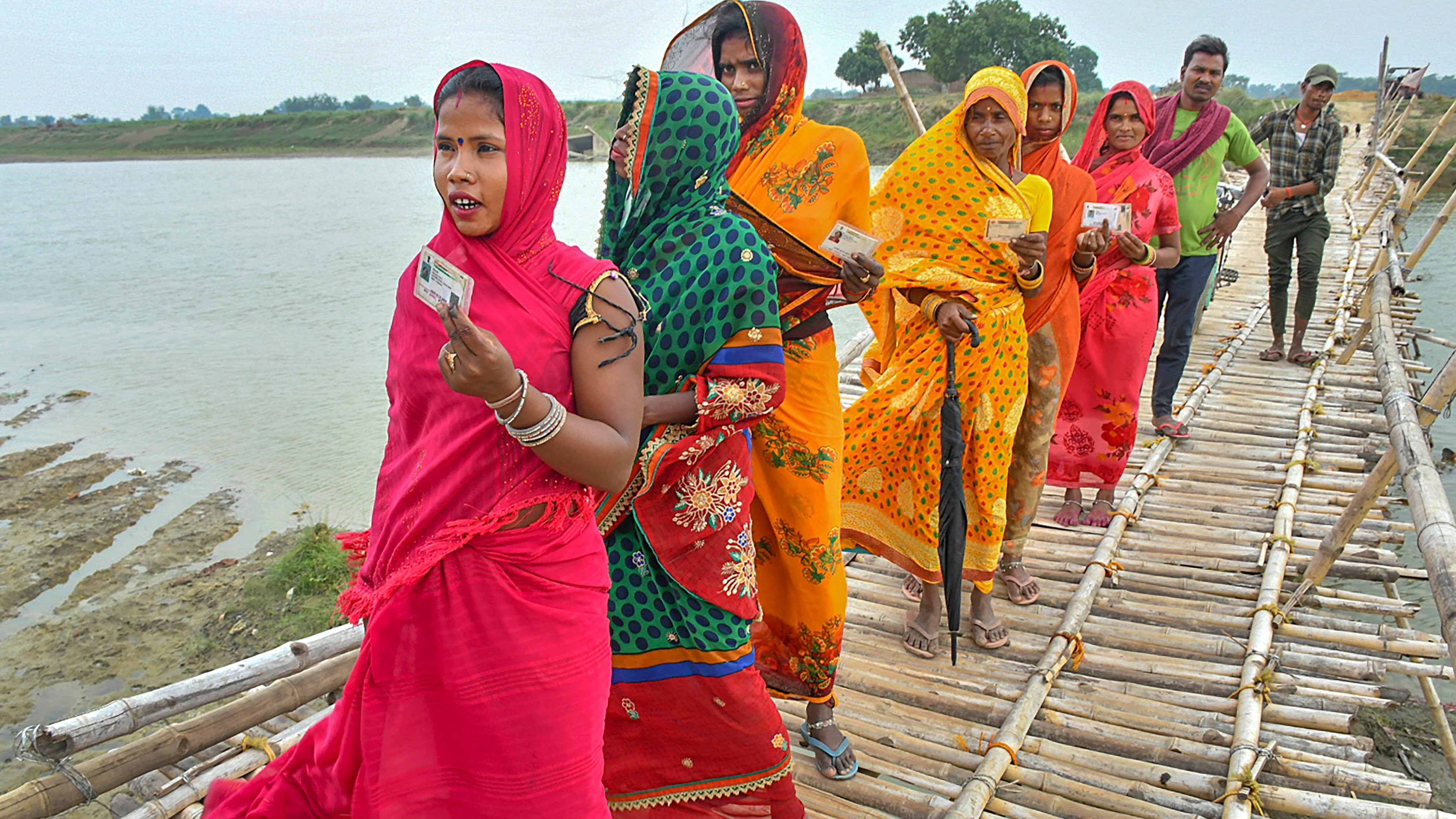 Voters cross a bridge on their way to a polling booth to cast their votes for the fifth phase of Lok Sabha elections, in Muzaffarpur, Bihar.