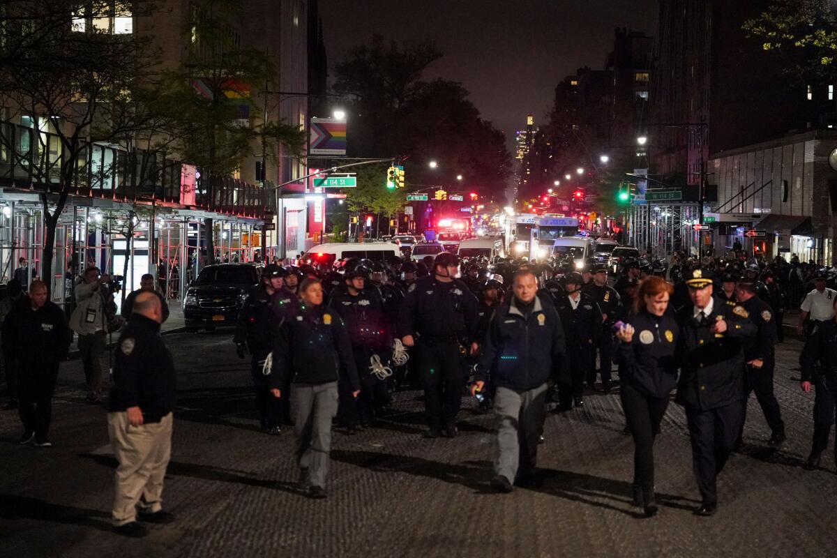Police walk around Columbia University, as other police officers enter the campus of the university, during the ongoing conflict between Israel and the Palestinian Islamist group Hamas, in New York. 
