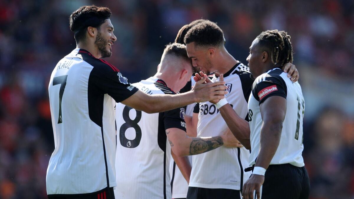Fulham's Adama Traore celebrates scoring a goal with Raul Jimenez and others.