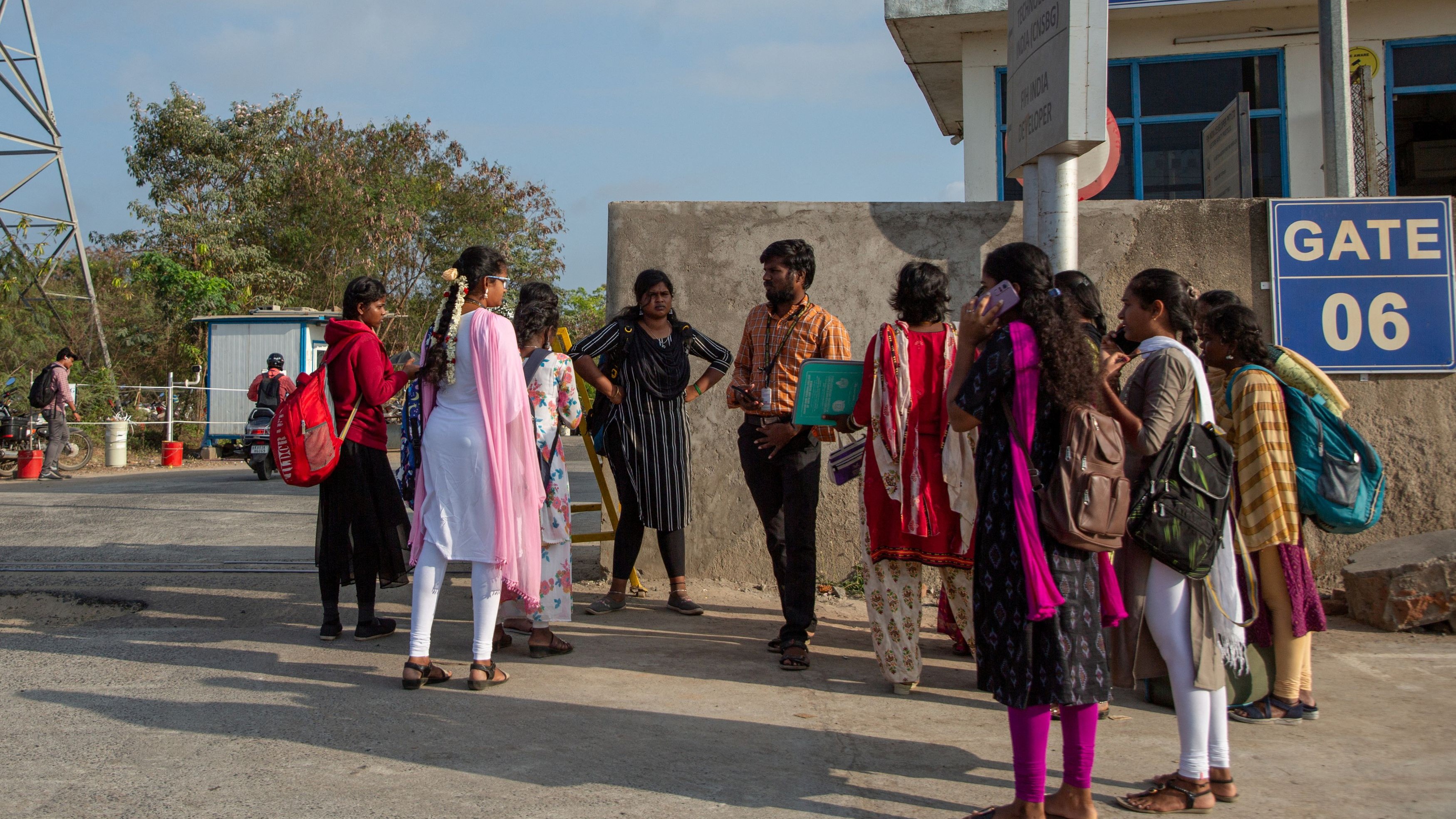 Job aspirants talk with a hiring agent outside the Foxconn plant in Sriperumbudur.