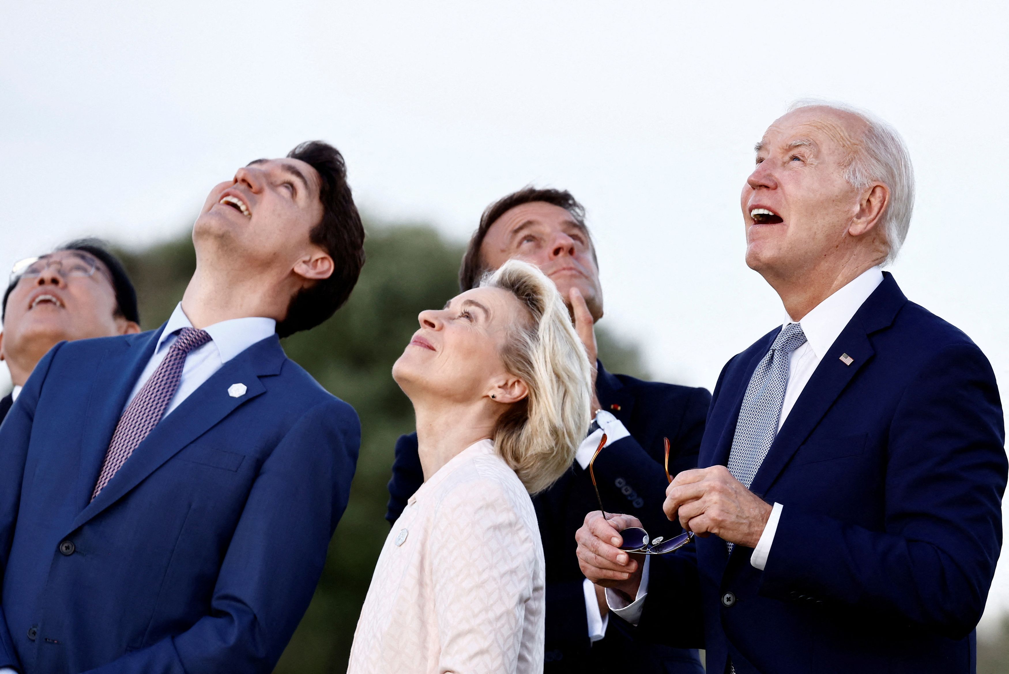 U.S. President Joe Biden, Canada's Prime Minister Justin Trudeau, France's President Emmanuel Macron, Japan's Prime Minister Fumio Kishida, ?and European Commission President Ursula von der Leyen look on during a skydiving demonstration on the first day of the G7 summit, in Savelletri, Italy.