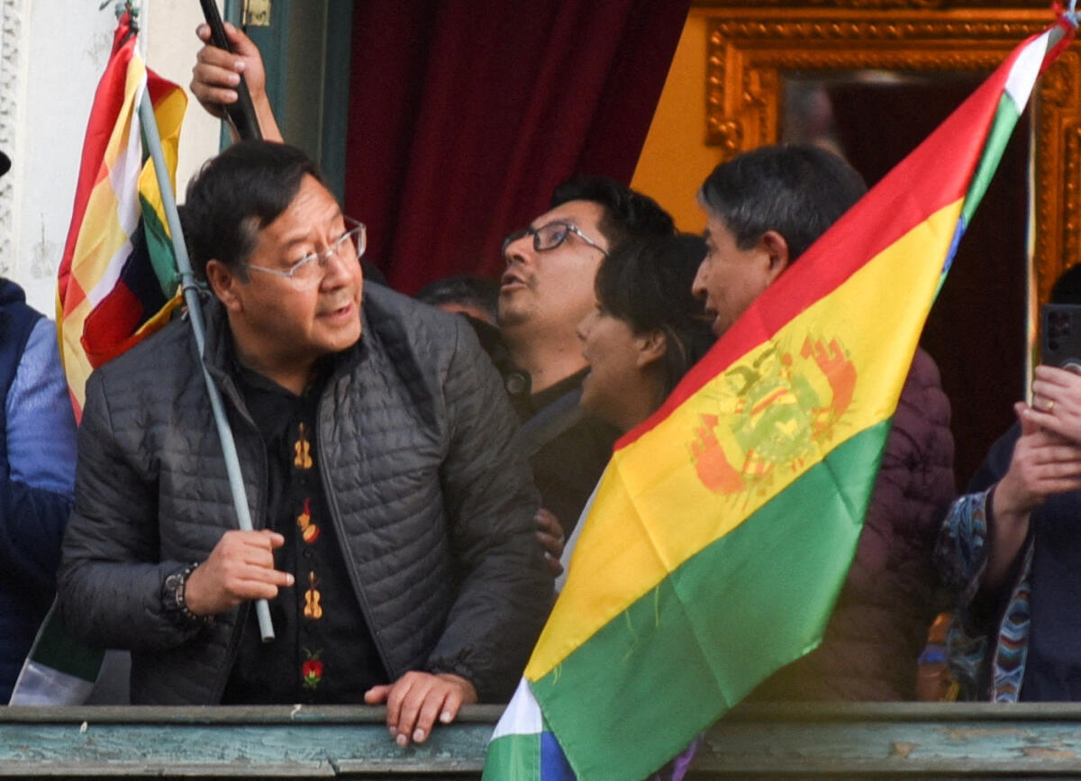 Bolivia's President Luis Arce holds a flag as he stands on a balcony after he "denounced the irregular mobilization" of some units of the country's army in La Paz, Bolivia, June 26, 2024.