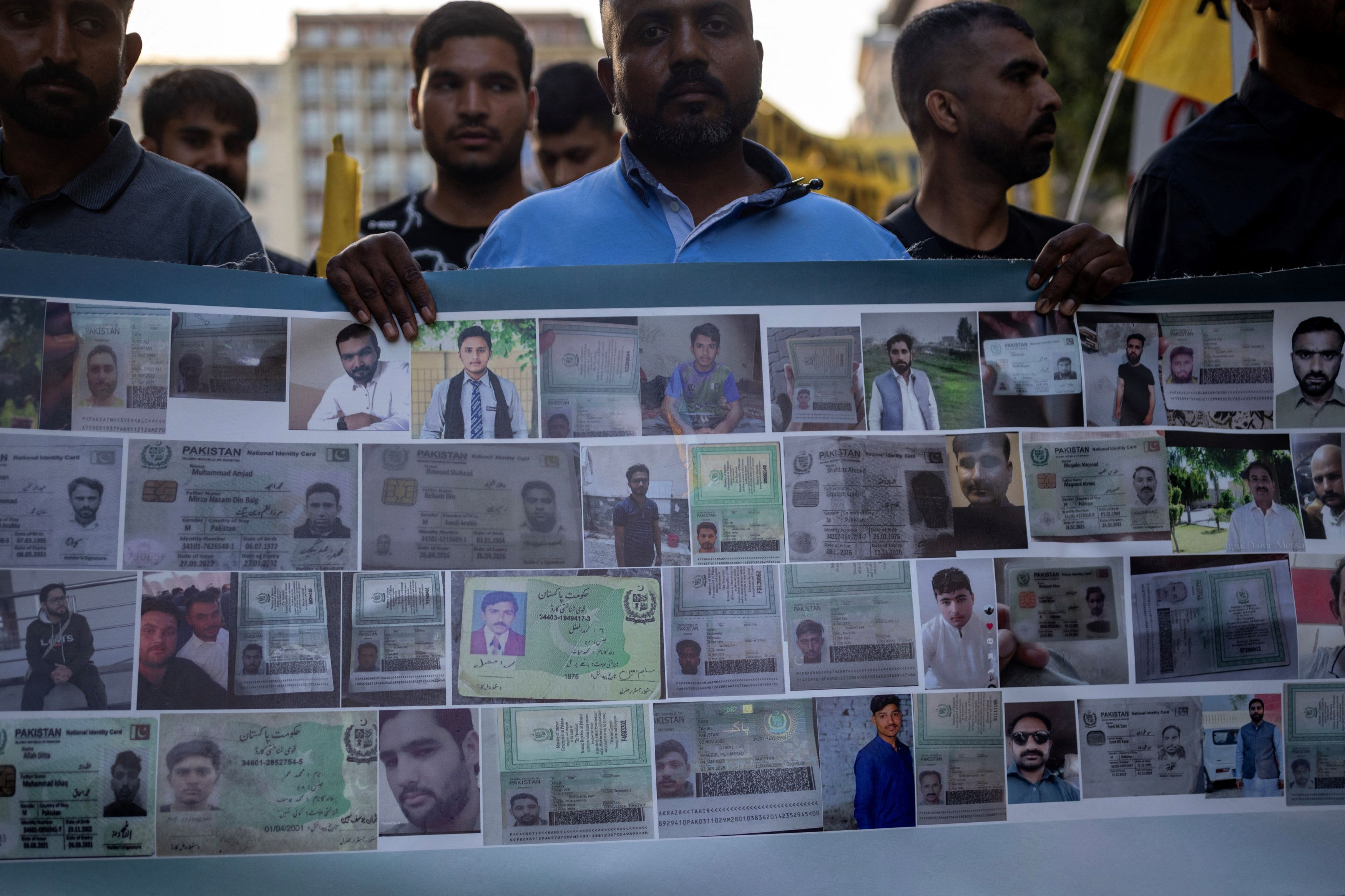 Protesters, some of them survivors of a deadly migrant shipwreck off southwestern Greece, hold a banner with photos of the missing during a demonstration marking a year from the shipwreck, in Athens Greece, June 14, 2024.