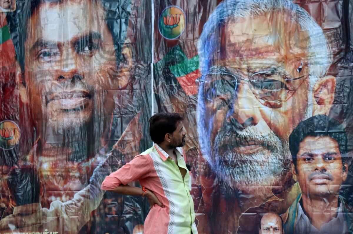 A man stands in front of a poster featuring Prime Minister Narendra Modi and BJP election candidate K. Annamalai, outside its party office in Chennai, India, June 4, 2024.