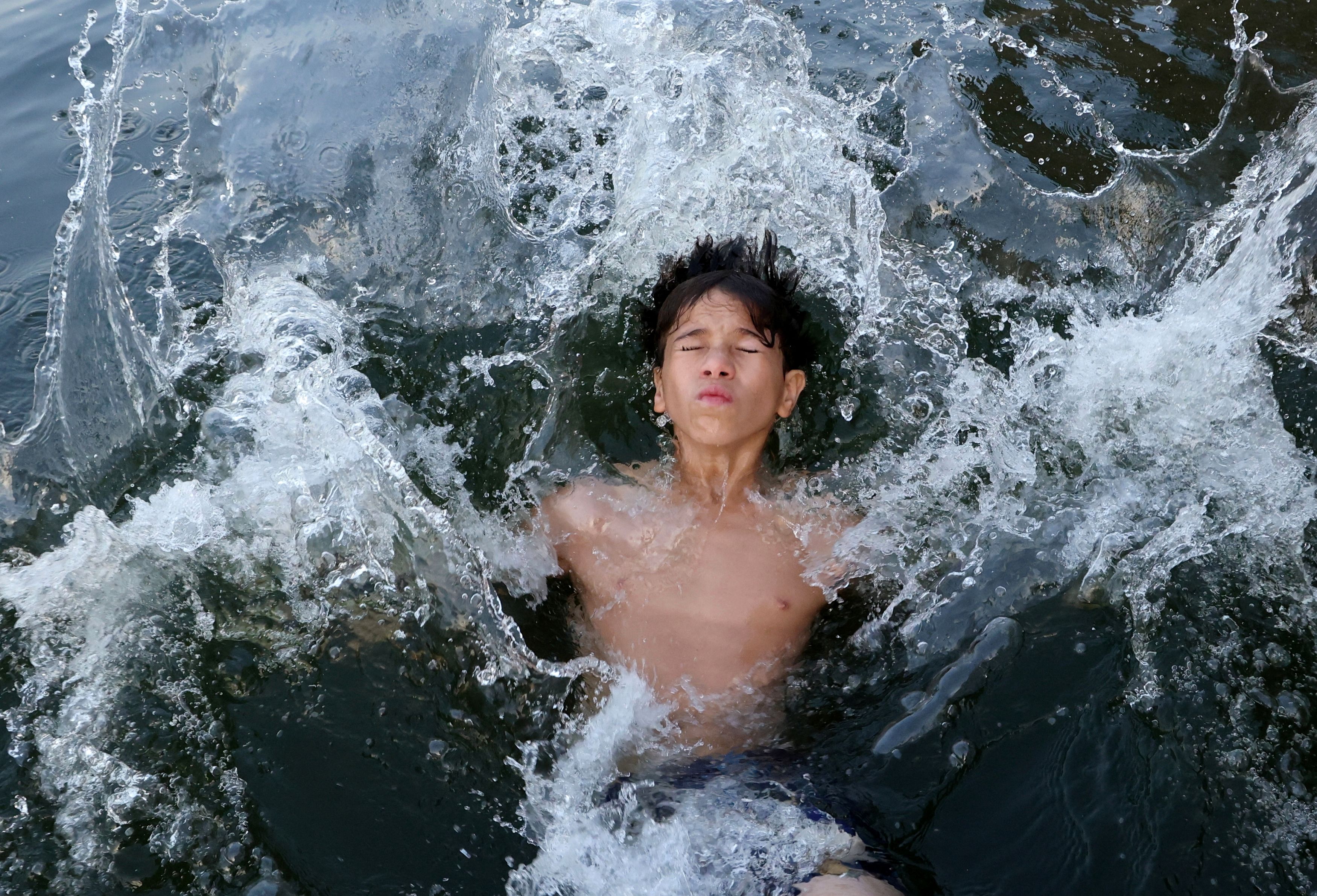 A boy swims in the Nile River amid a heatwave in El Qanater El Khayreya city, in Al Qalyubia Governorate, Egypt, June 14, 2024.
