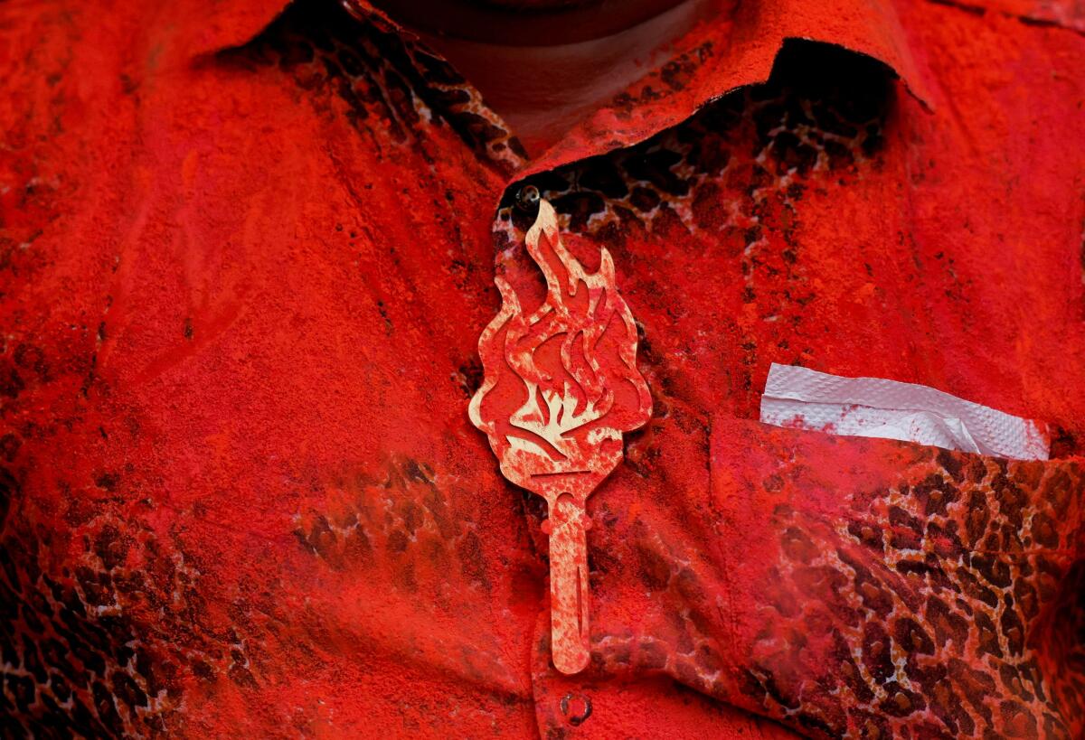 A person wears a badge of Shiv Sena (Uddhav Balasaheb Thackeray) party election symbol as it's smeared with colour after celebrations at the party office after election results outside the party office in Mumbai, India, June 4, 2024.