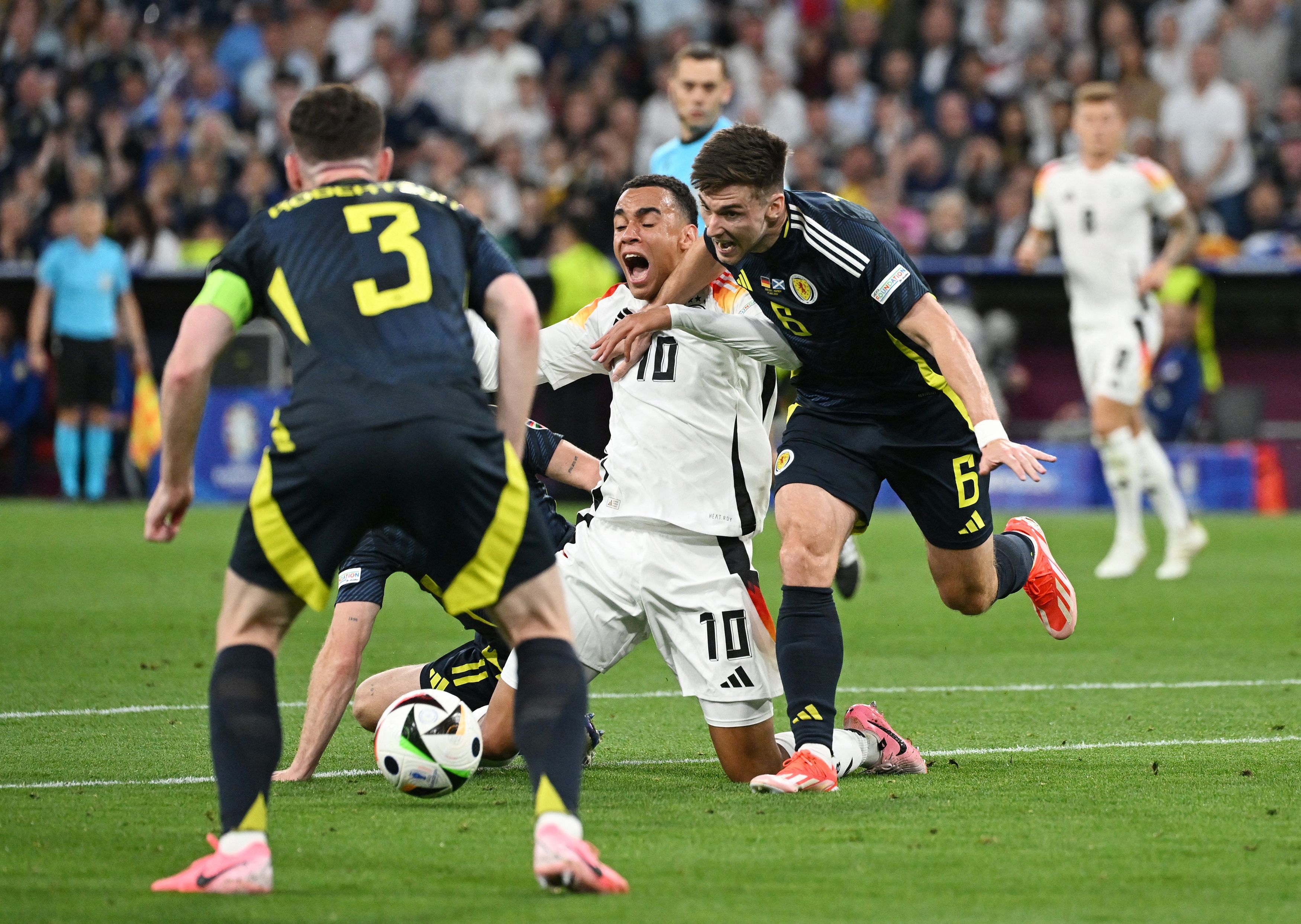 Germany's Jamal Musiala reacts after being fouled by Scotland's Ryan Christie. 