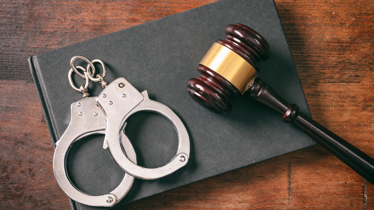 Representative image showing a book, handcuffs, and a gavel.