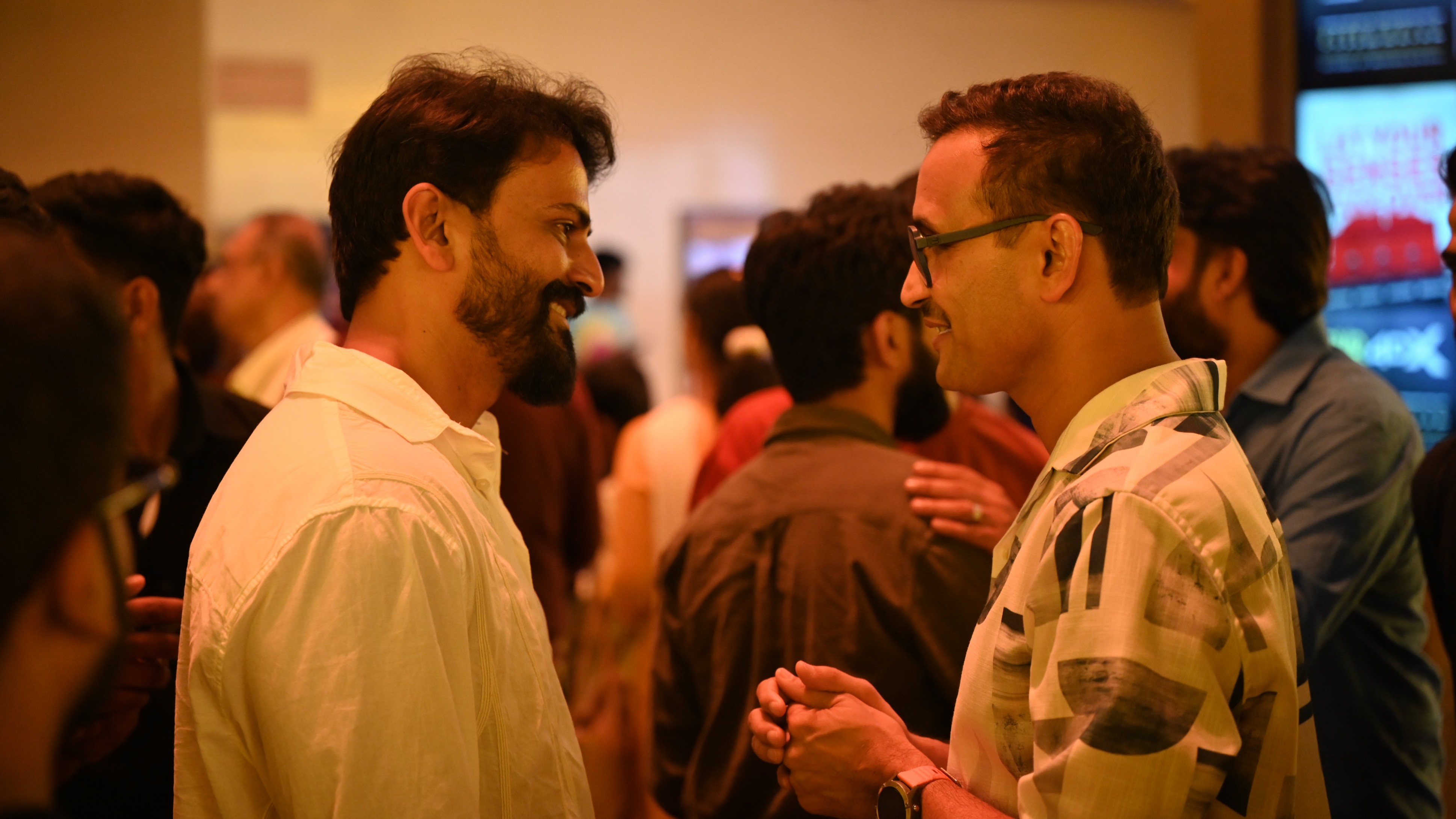 Daali Dhananjaya is seen engrossed in a deep conversation with Parameshwar Gundkal during the premiere of Kotee in Bengaluru.