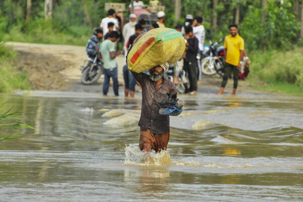 People cross a waterlogged street after rainfall in Uttar Pradesh's Moradabad on July 8, 2024.