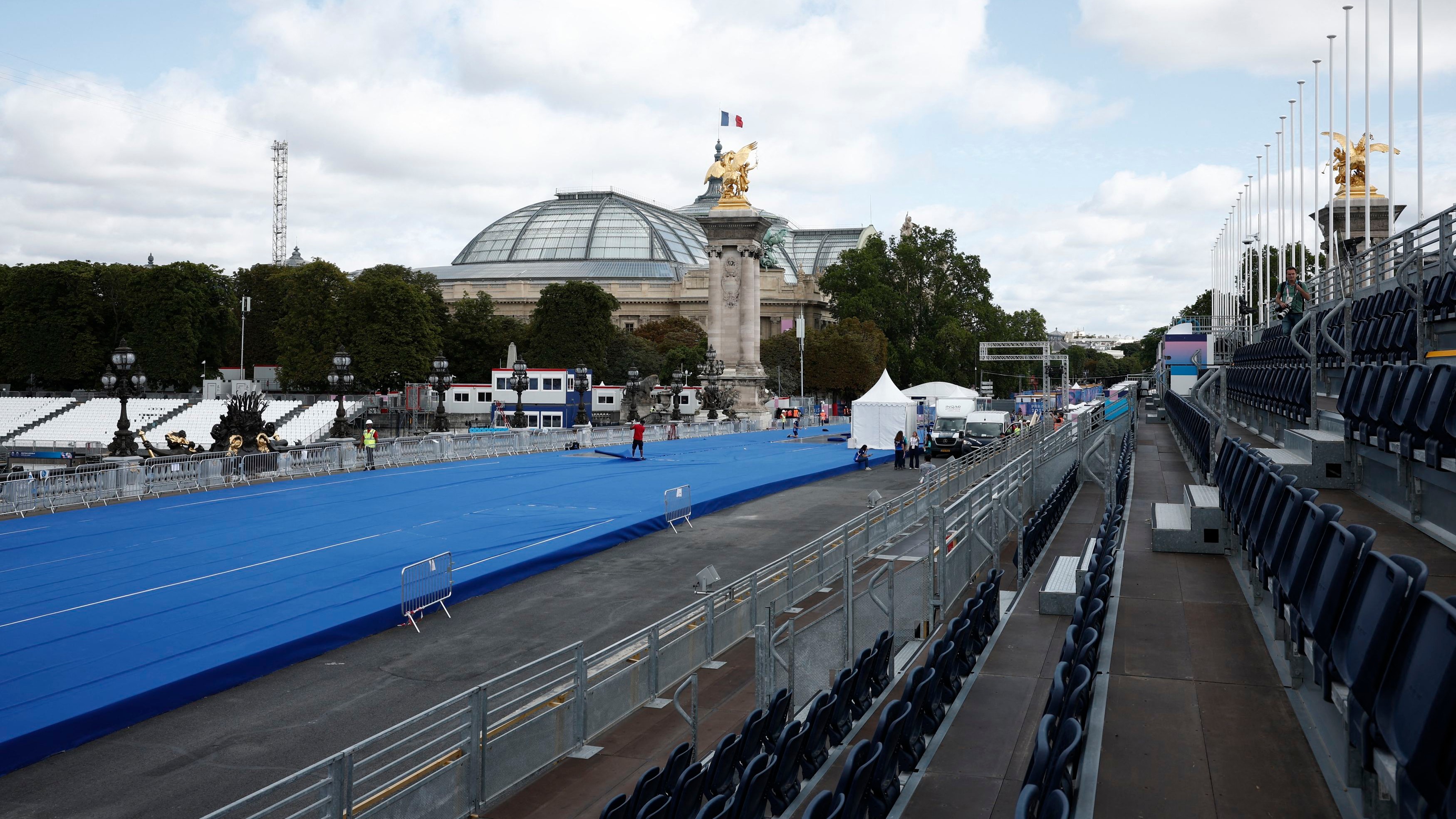 Workers prepare the Triathlon piste on the Pont Alexandre III bridge, in Paris.