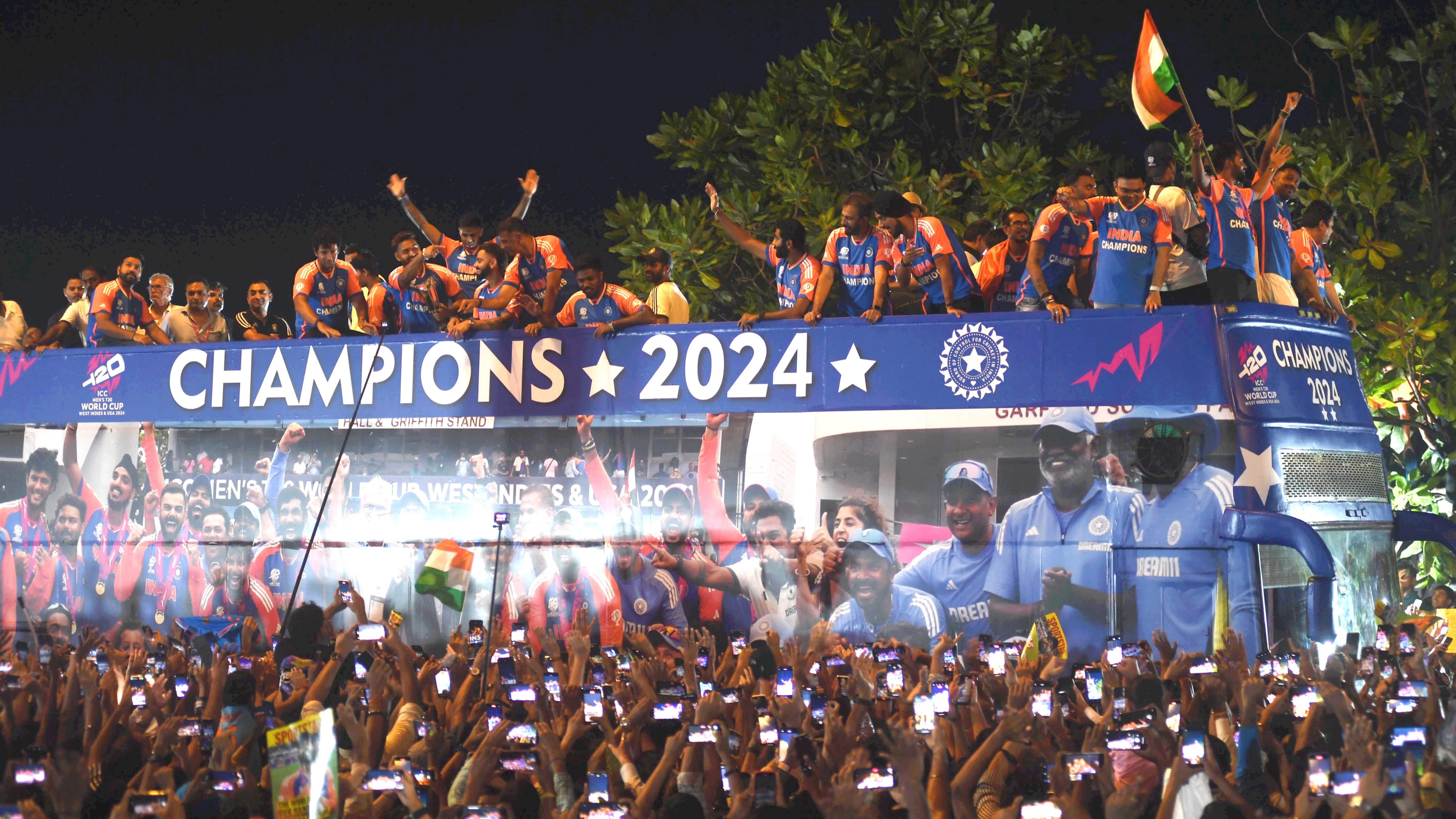 Players of the T20 World Cup-winning Indian cricket team acknowledge fans during their open bus victory parade, in Mumbai.