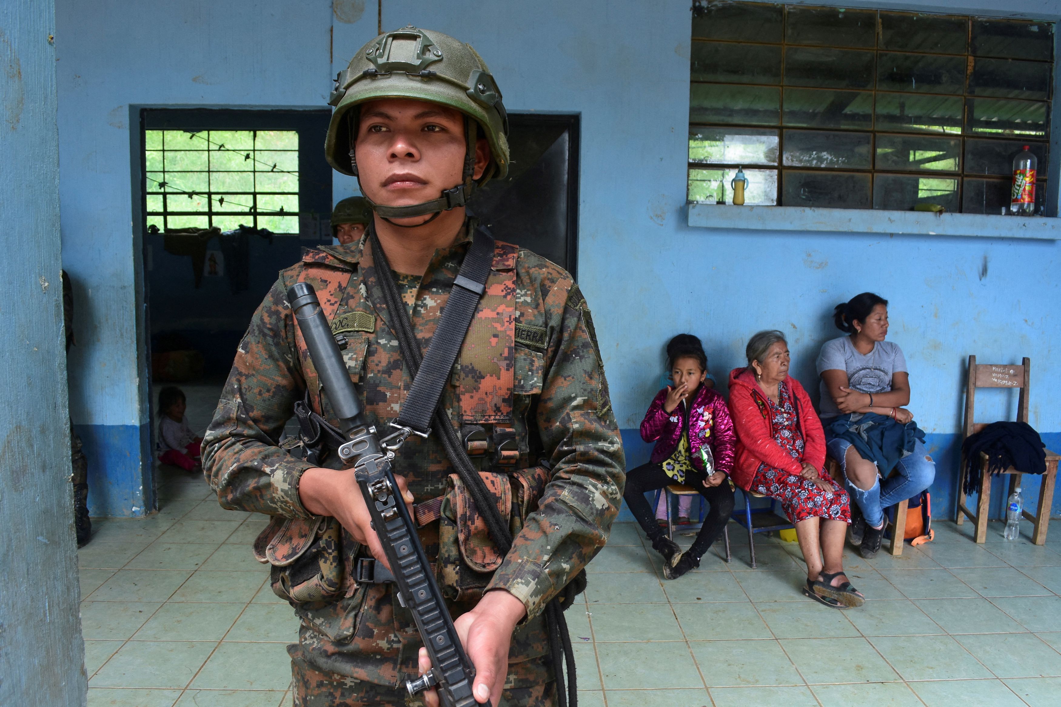 A Guatemalan soldier keeps watch outside a classroom near Mexicans citizens who fled to neighboring Guatemala amid armed clashes between criminal groups fighting over drug trafficking routes and other crimes, in Cuilco, Guatemala, July 26, 2024.