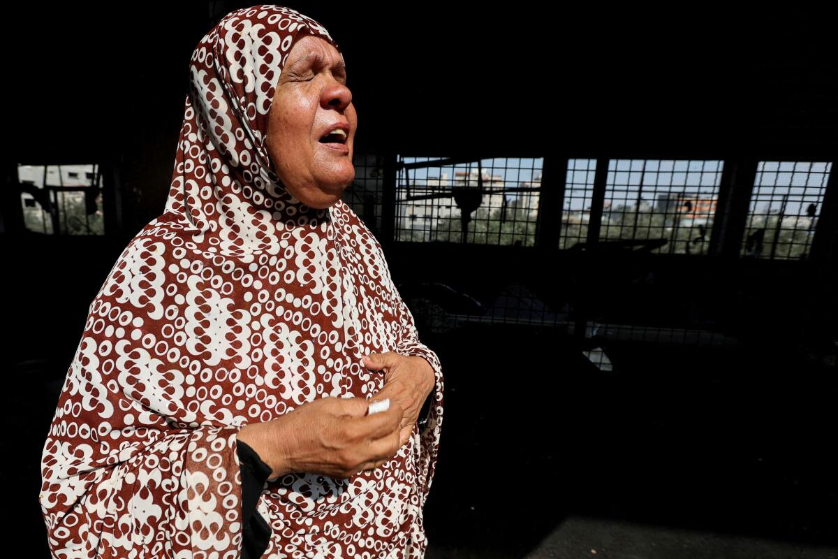 A Palestinian woman reacts after an Israeli air strike on a UN school sheltering displaced people, amid the Israel-Hamas conflict.