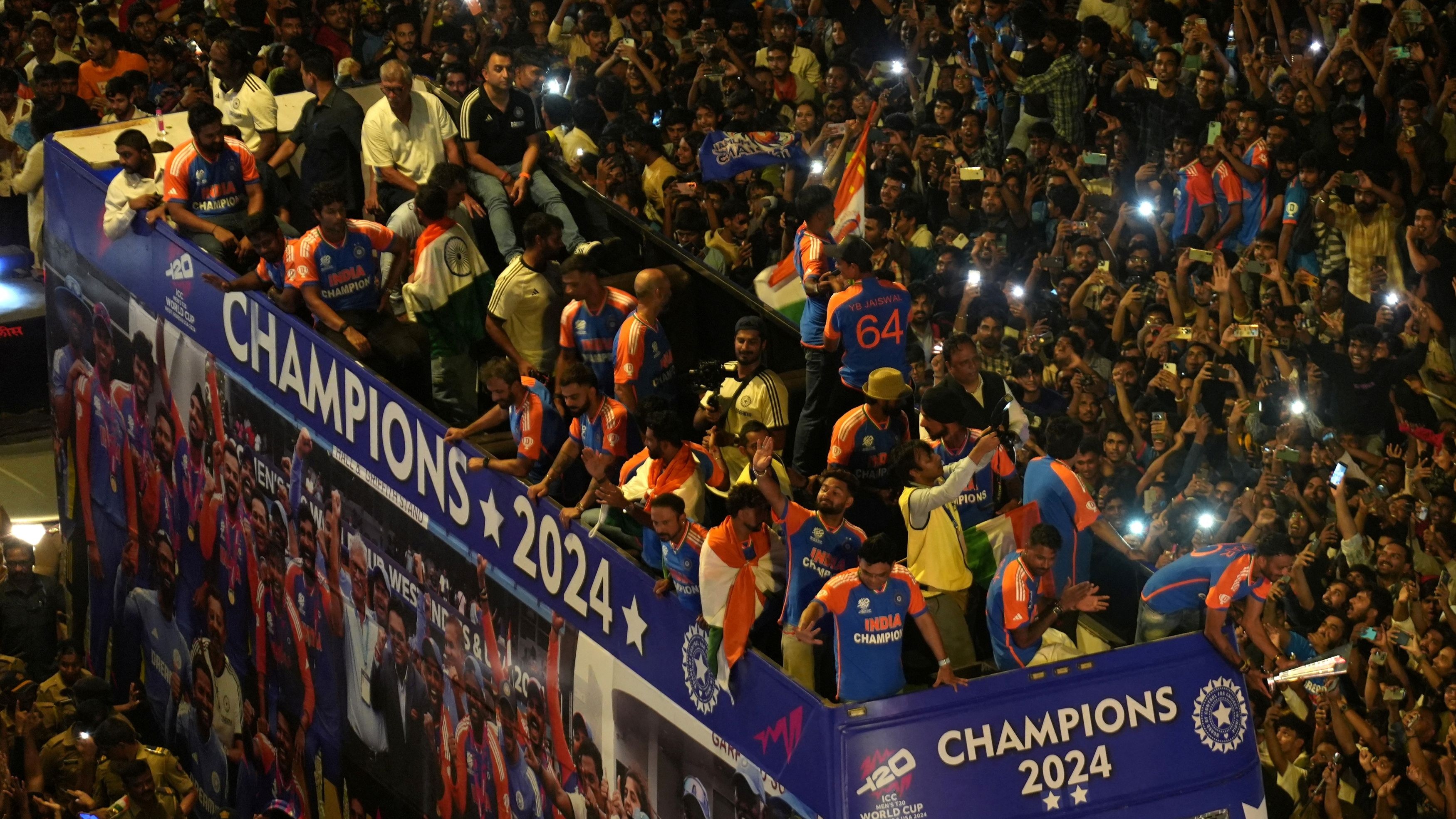 India cricket team members greet their fans as they take part in a parade to celebrate winning the ICC men's T20 World Cup, in Mumbai.