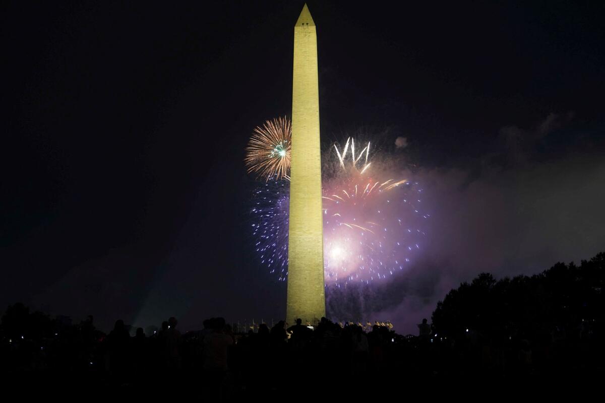 Spectators watch as fireworks explode near the Washington Monument during Fourth of July celebrations in Washington.