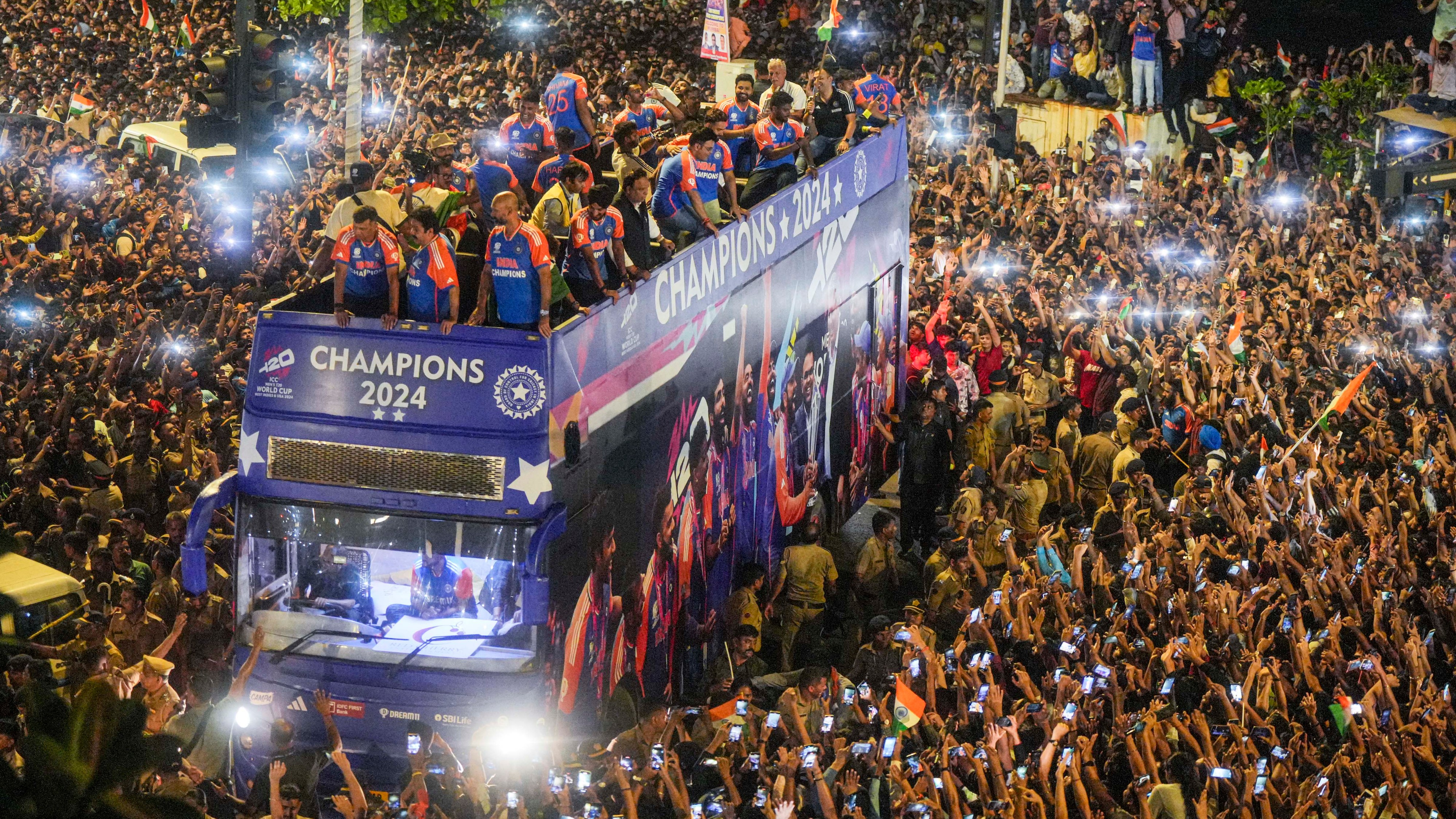 Players of the T20 World Cup-winning Indian cricket team acknowledge fans during their open bus victory parade, in Mumbai.