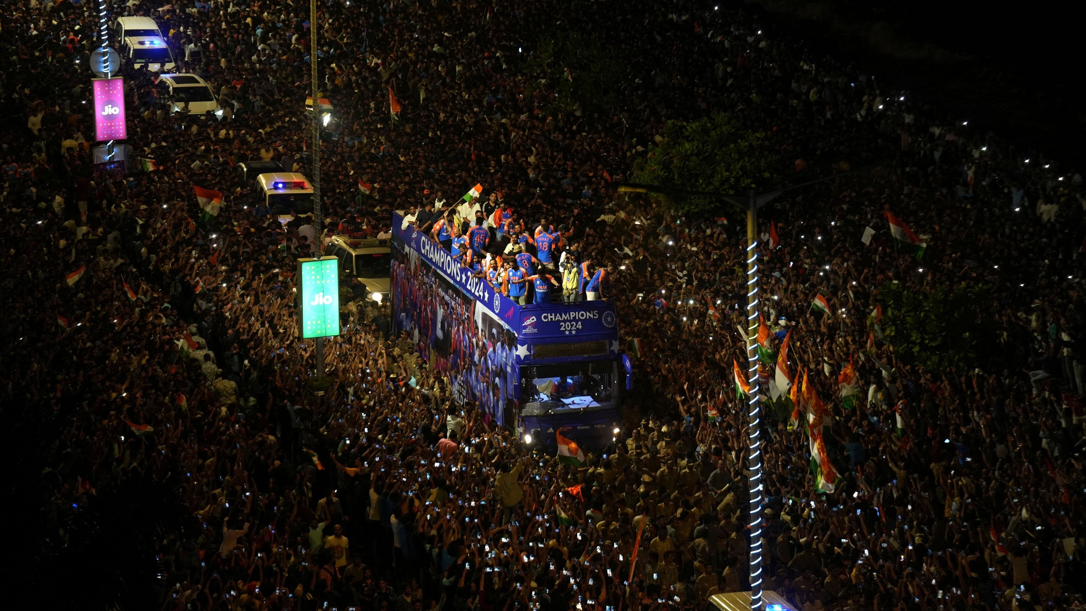 Fans crowd around a bus as Indian cricket team members take part in a parade to celebrate winning the ICC men's T20 World Cup, in Mumbai.