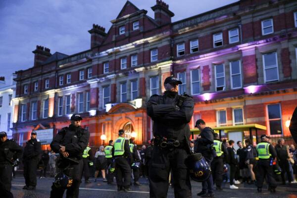 Police officers stand guard outside a mosque during a protest in Liverpool, Britain.